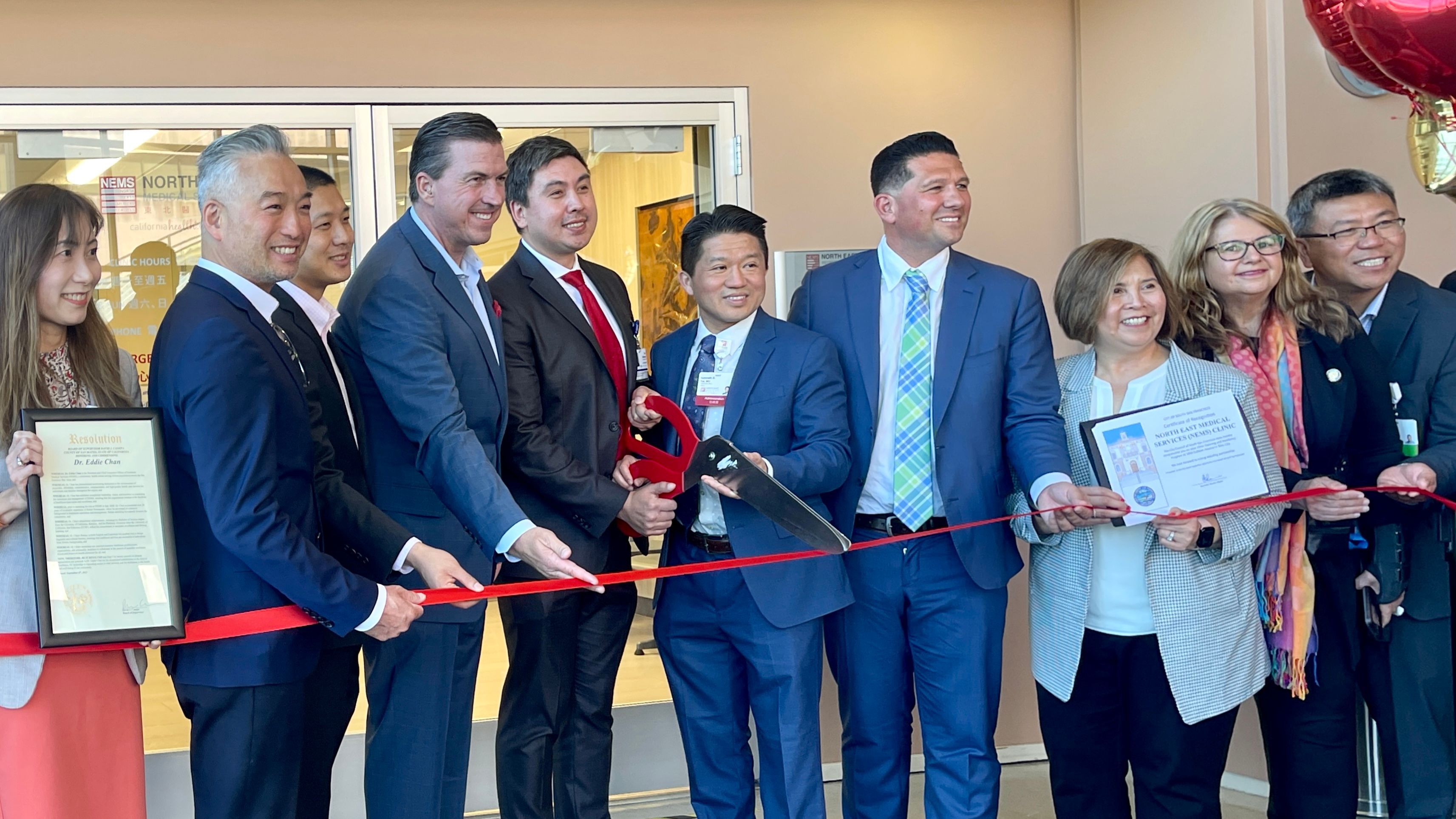 Elected officials in San Mateo County join Dr. Kenneth Tai (fifth from far right) of NEMS in the ribbon cutting ceremony to celebrate the opening of Sullivan Clinic at Seton medical Center. Photo by Portia Li