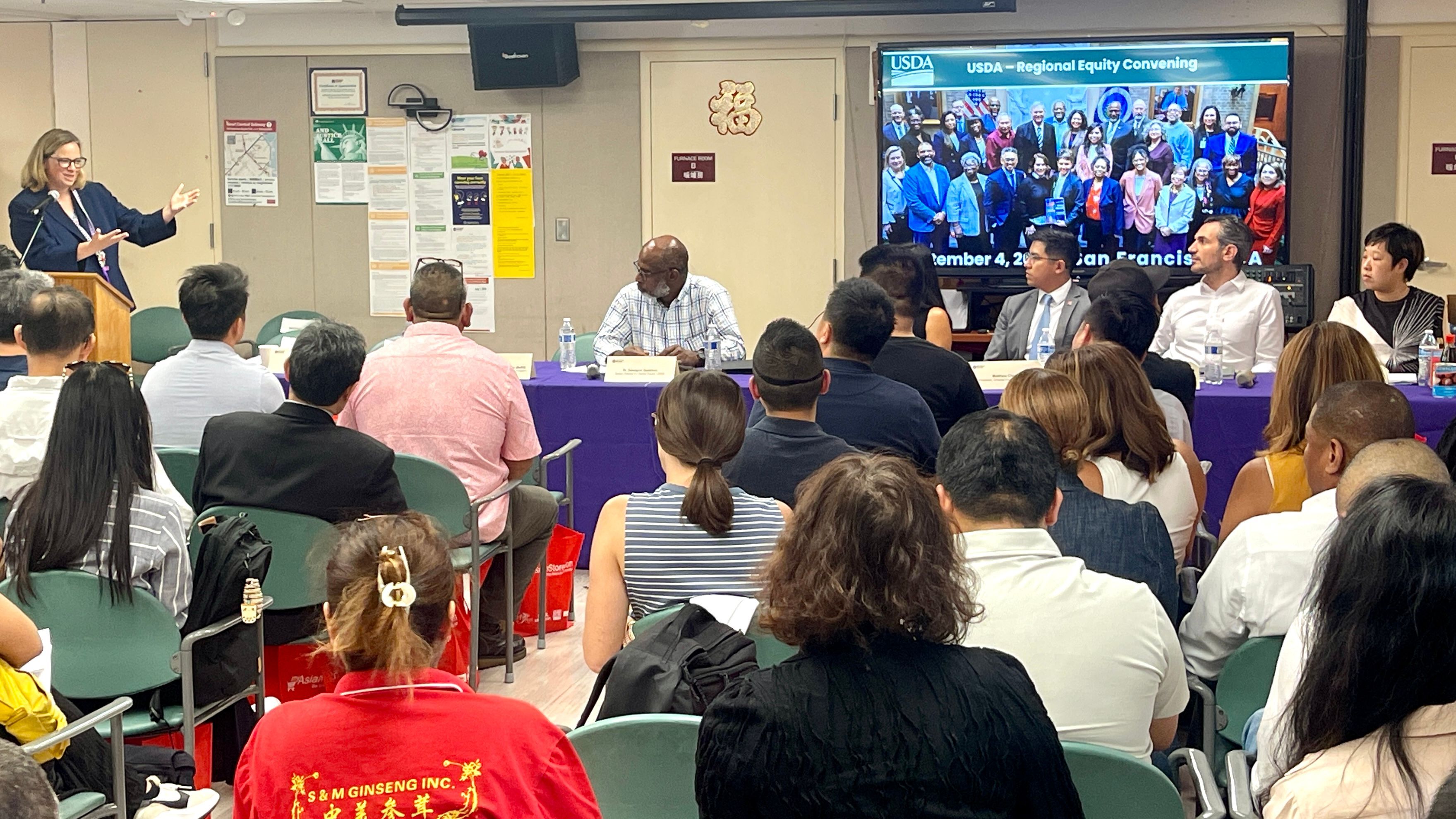 Jennifer Lester Moffitt (standing at left), Under Secretary of U.S. Department of Agriculture, speaks at the Northern California Regional Rquity Convening hosted by the Self-Help for the Elderly in San Francisco Chinatown. Photo by Portia Li