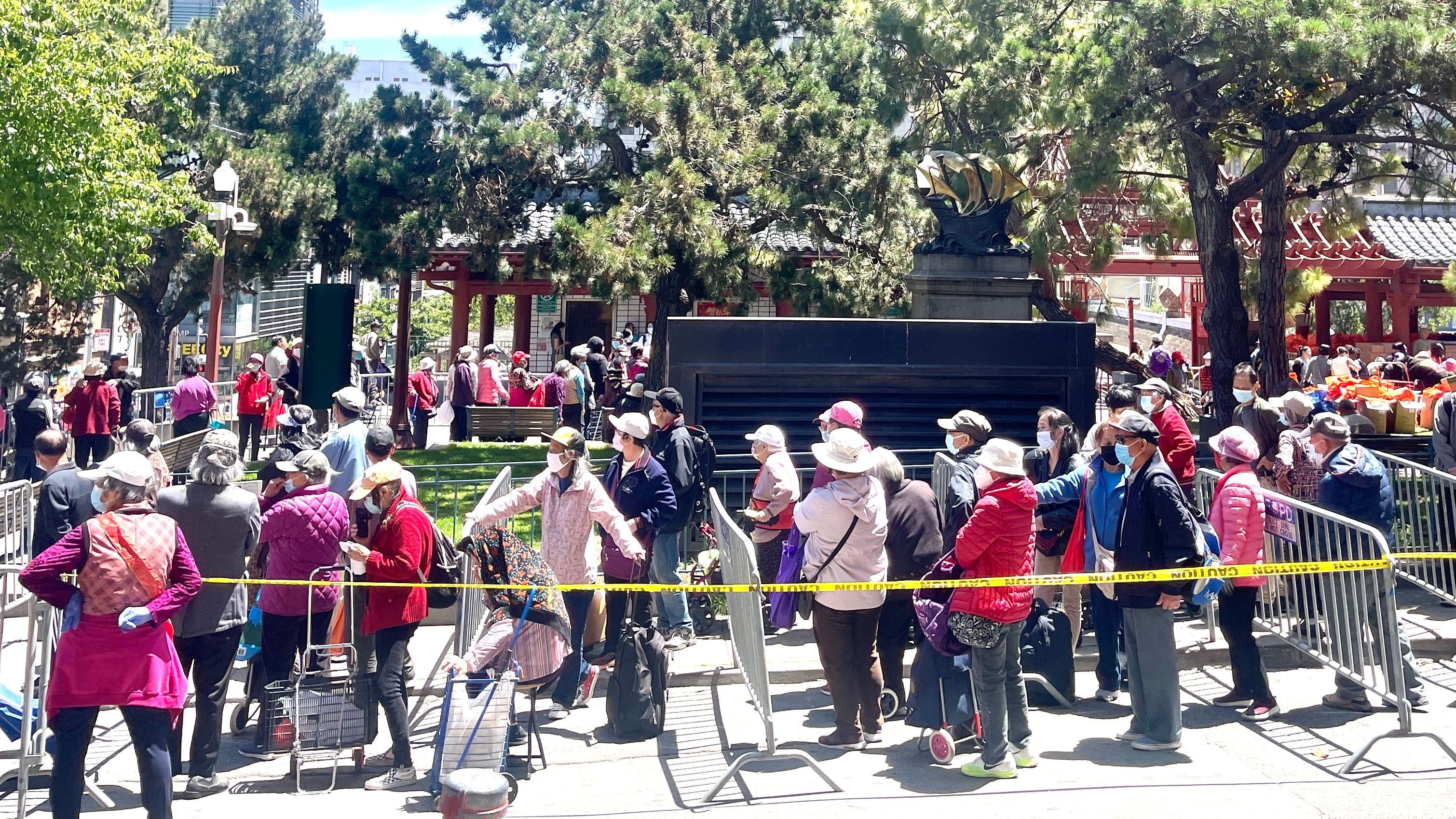 Over 4,000 community members line up for the food bags and the distribution lasts for 4 to 5 hours. Photo by Portia Li