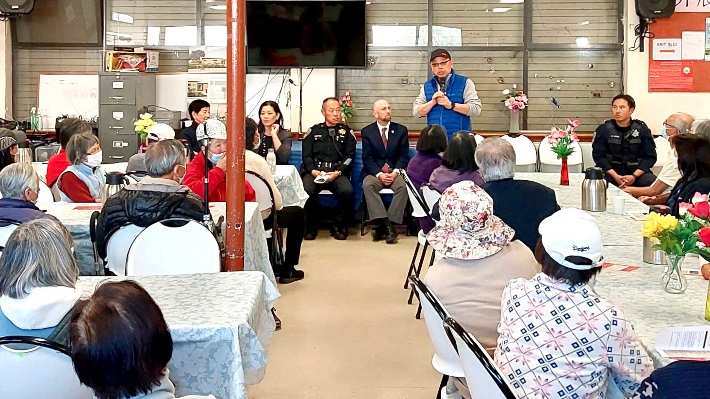 Officer Eddie Wu (standing) of SFPD Community Engagement Division provides crime prevention and latest blessing scam information to seniors at the Self-Help for the Elderly Sunset Recreation Center. Courtesy SFPD