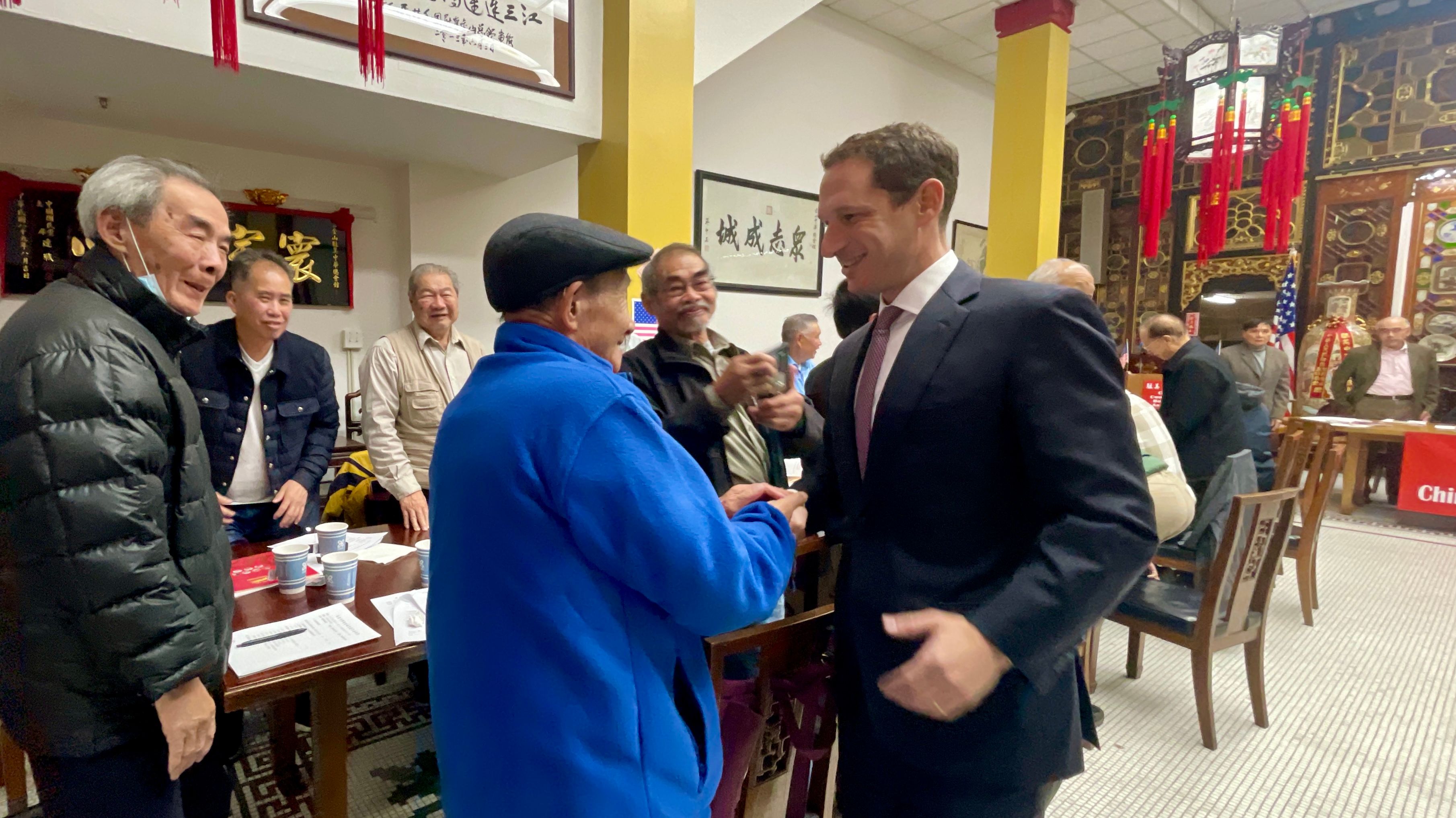 Mayor-Elect Daniel Lurie thanks for the support from the Chinese community and shakes hands with all board members at CCBA, including senior board member Thomas Ng (in blue jacket). Photo by Portia Li