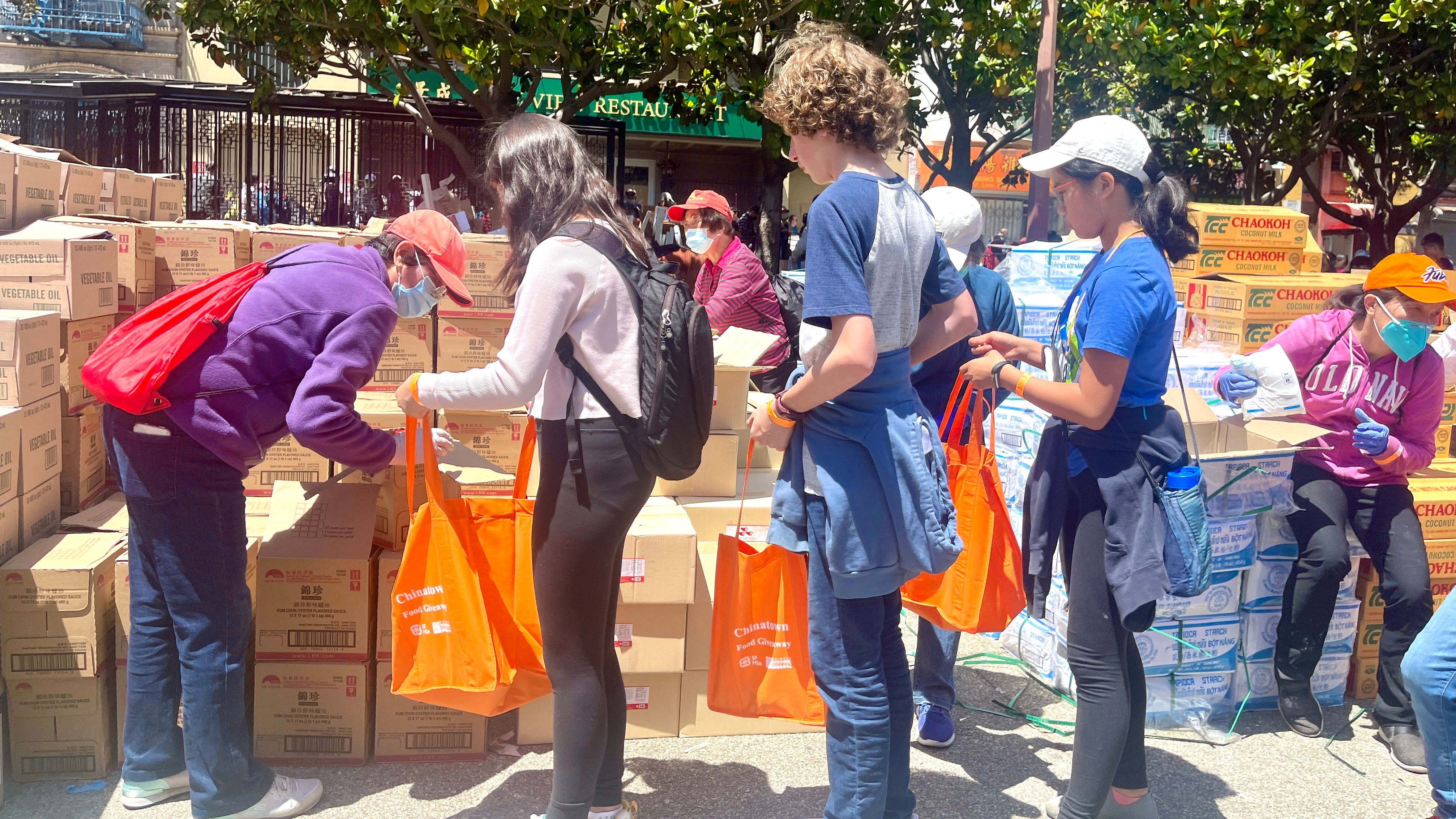 Volunteers include students are helping out to put over 20 food items into each bag. Photo by Portia Li