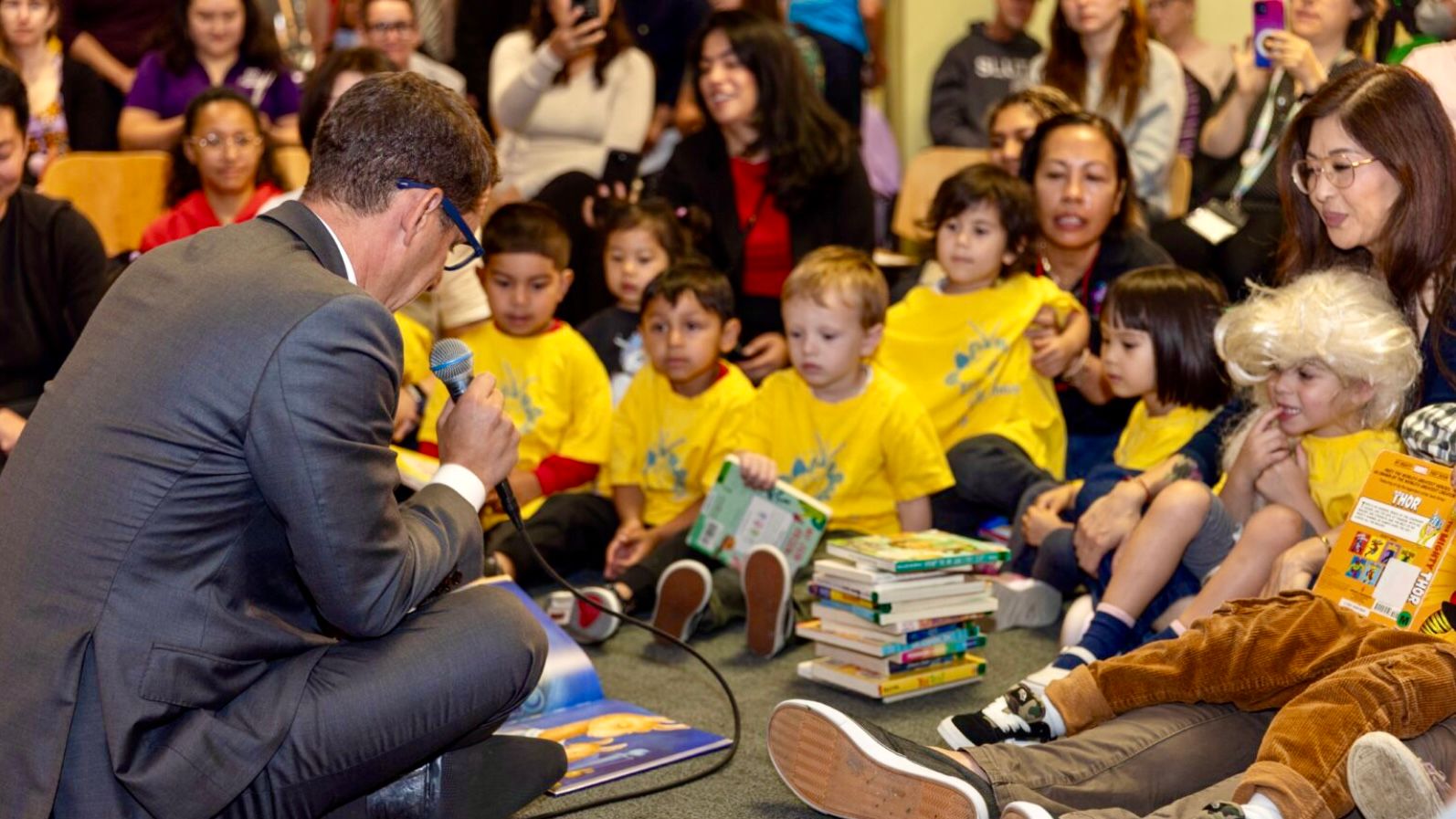 Mayor Daniel Lurie (left) reads a book to a group of young children at the San Francisco Main Library in September 2025 when he announces the City’s newly-established partnership with Dolly Parton’s Imagination Library to provide free books monthly to children aged 0 to 5 in San Francisco. Courtesy Mayor Daniel Lurie on X