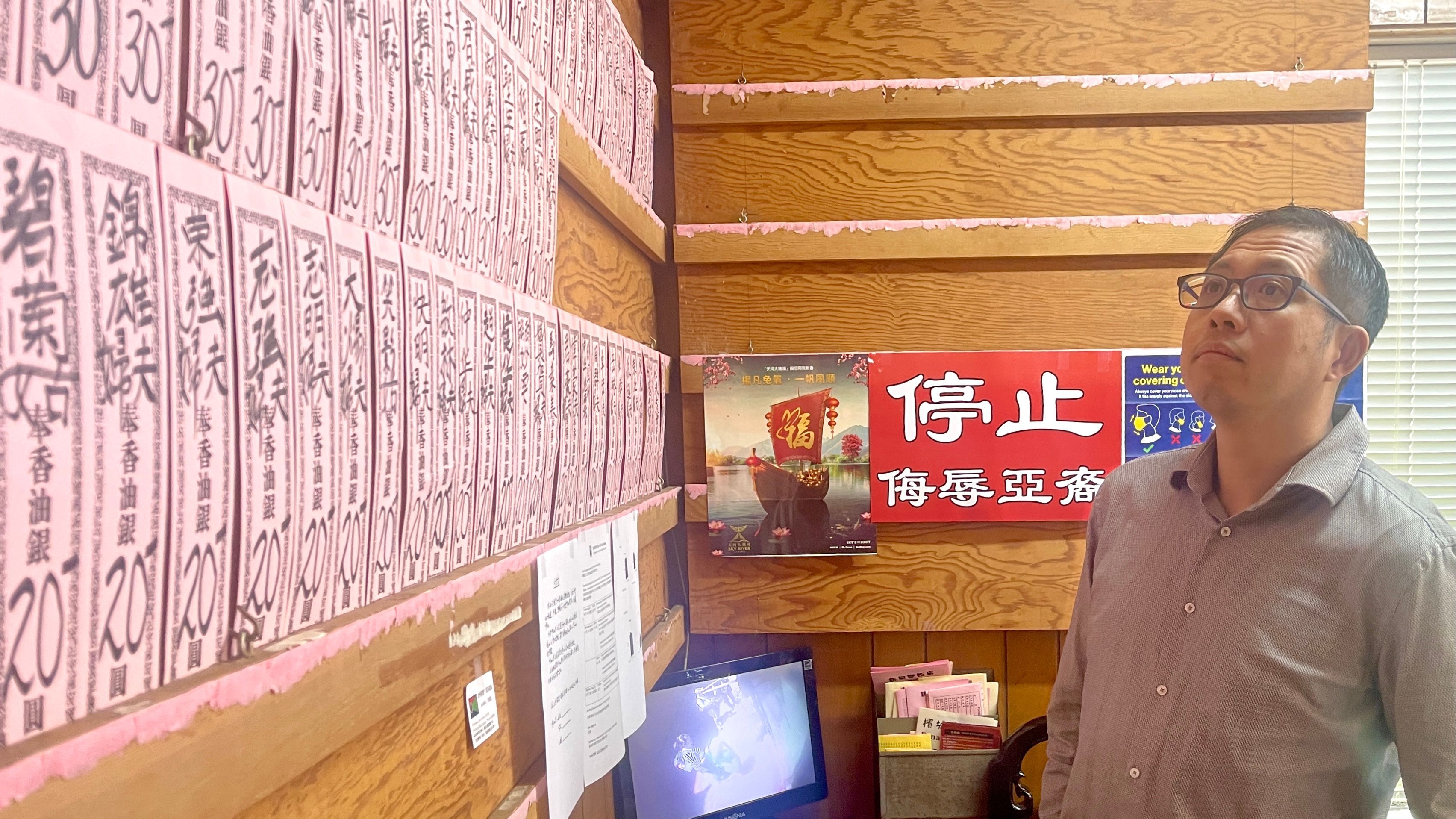 Thomas Lam looks at the donation records at the Lim Family Benevolent Society where he has joined as a member for 20 years. Photo by Portia Li