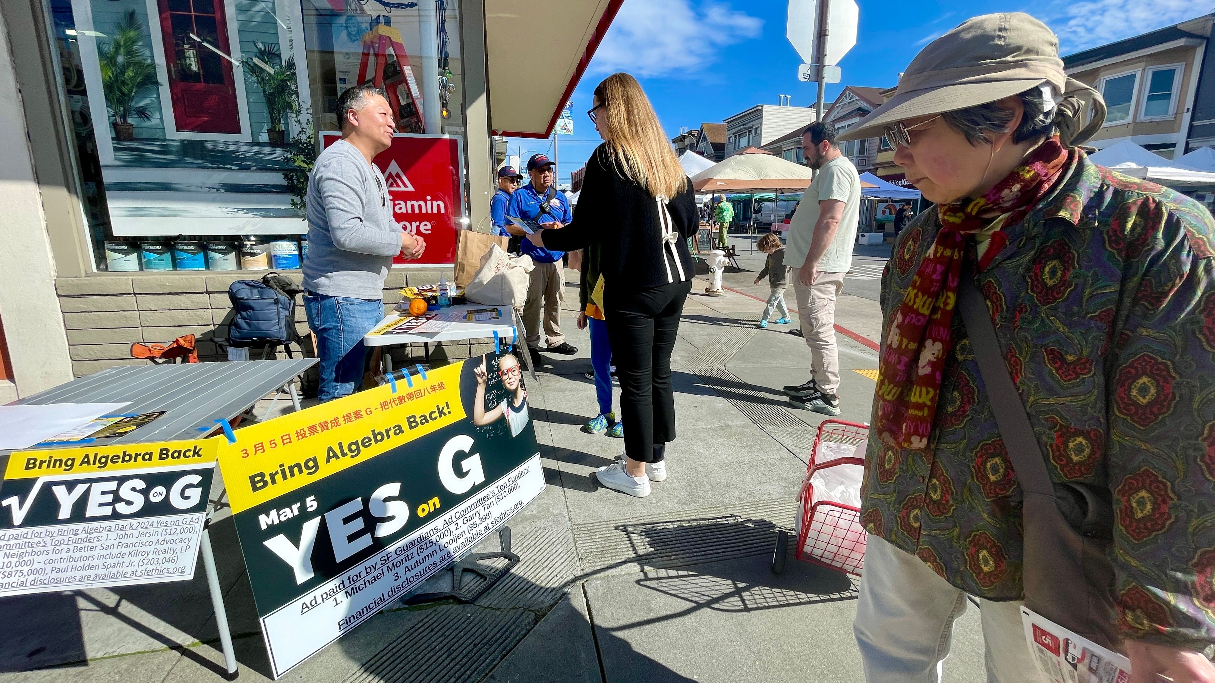 Kit Lam returns to the same old spot at Clement Street Farmers Market where he used to gather signatures for the recall petitions in 2021. This time Lam campaigns for Prop. G to bring back algebra classes.  Photo by Portia Li