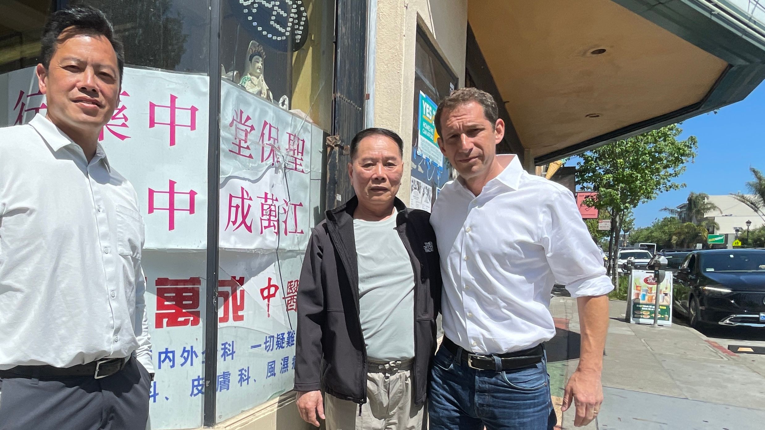 Mayoral candidate Daniel Lurie (right) holds a merchant walk with retired Police Commander Paul Yep (left) along the San Bruno Ave. and learns about the violence at Wan Chen Jiang’s (center) herb shop. Photo by Portia Li