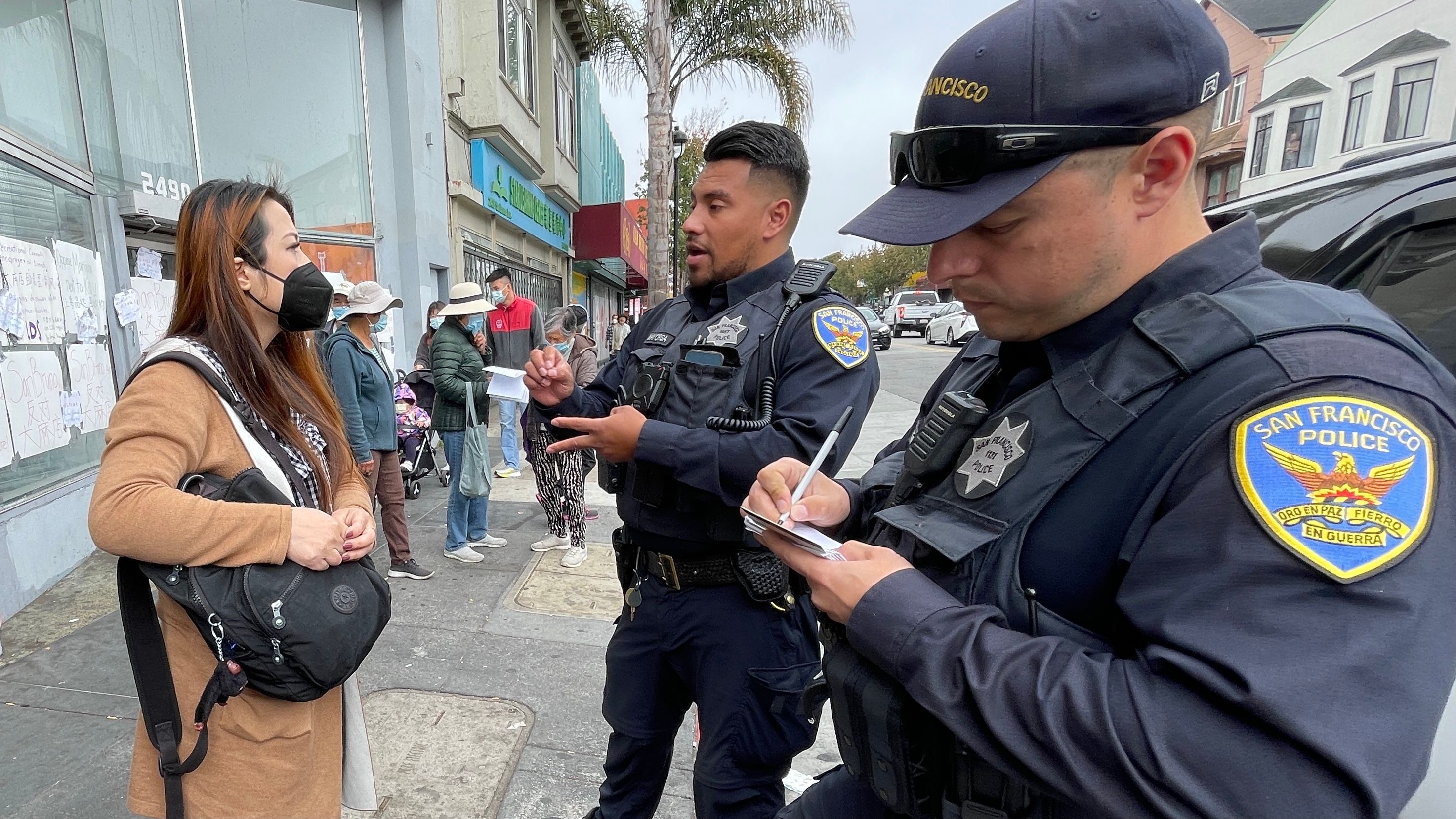 Selena Chu (left) speaks to police officers about the attack on her in the rally against a proposed cannabis store. Photo by Portia Li