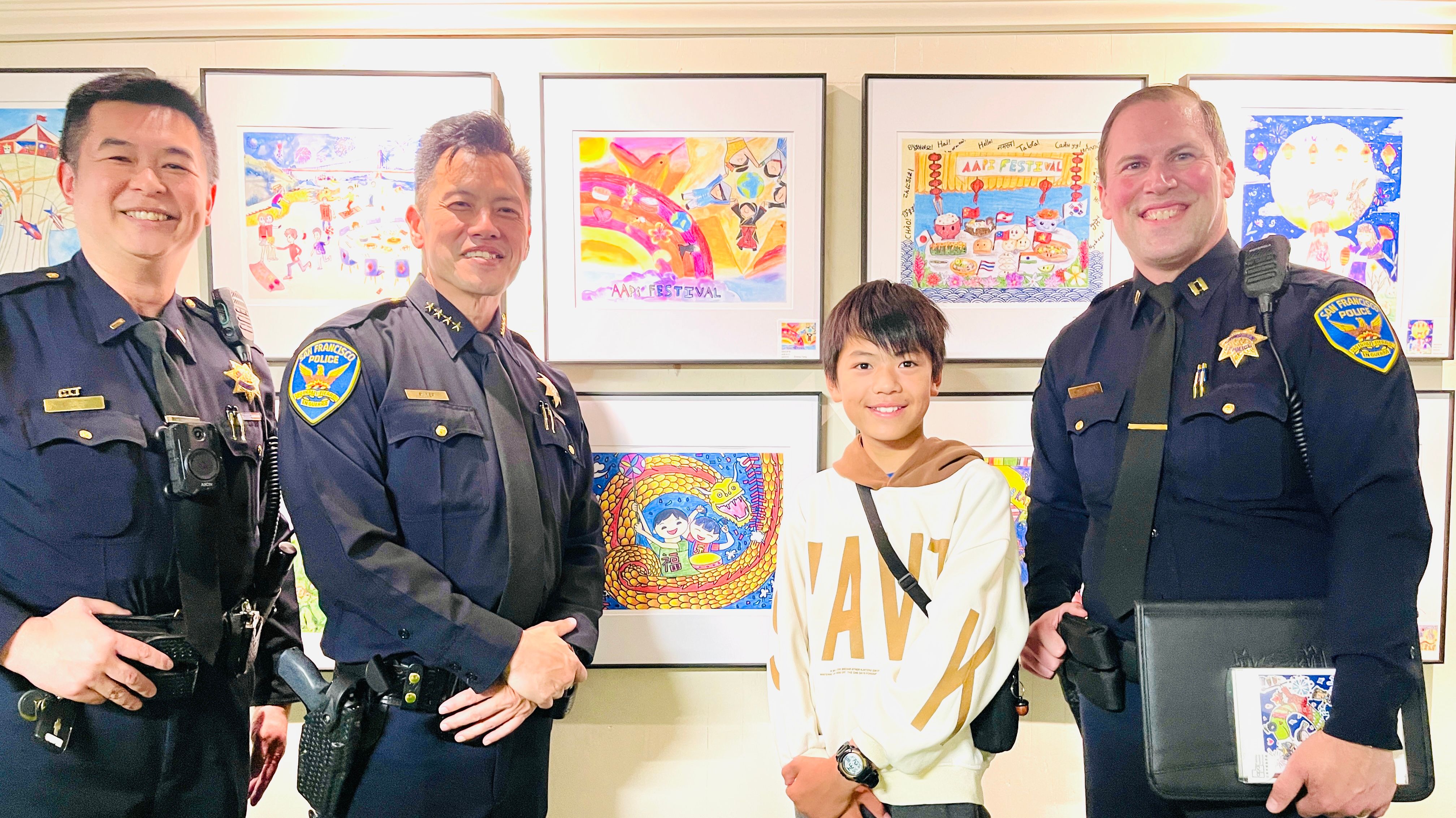 Lieutenant Kin Lee (from far left to right), Interim Police Chief Paul Yep and Central Police Station Captain Christopher Del Gandio congratulate merit winner Felix Kuang whose winning artwork was celebrating the Year of the Snake (artwork in 2nd row). Photo by Portia Li