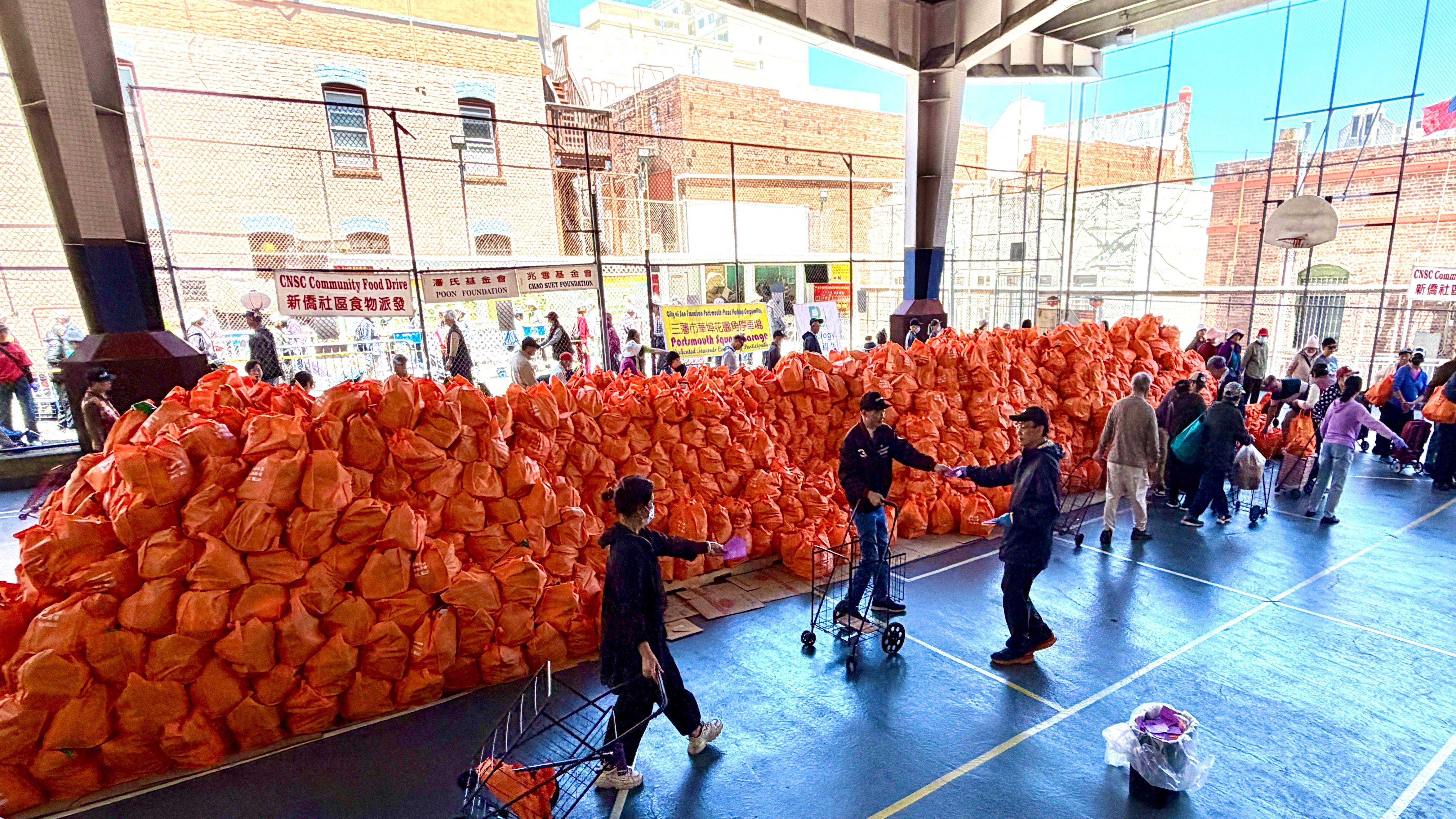 Through fundraising and volunteers, the 2026/33rd annual food giveaway event hosted by the Chinese Newcomers Service Center continues to distribute 5,000 food bags to seniors and low-income families who live in San Francisco. The distribution is held at the playgrounds of Cameron House and Central Chinese School in Chinatown. Photo by Portia Li