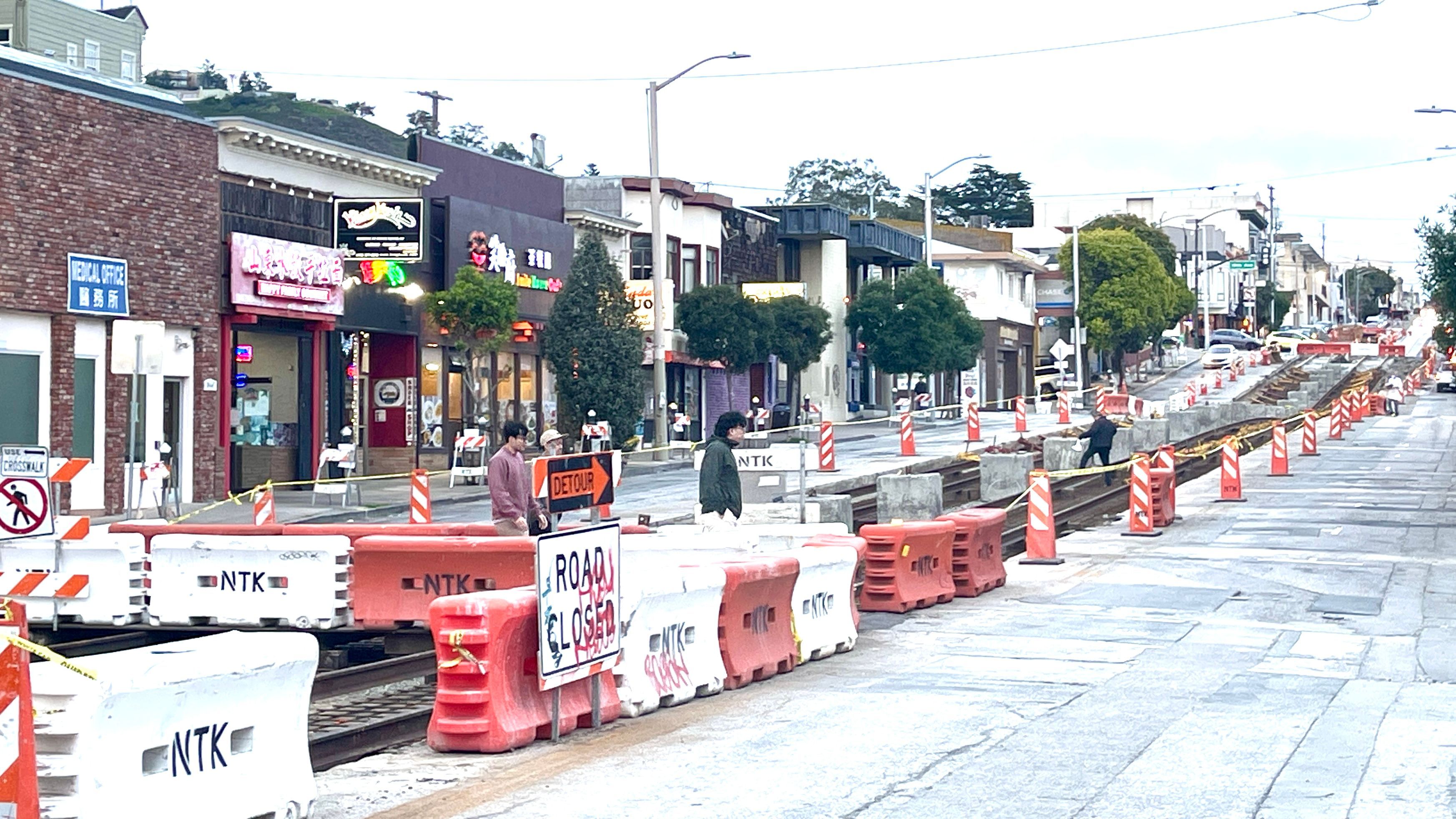 Residents and customers are delighted to see a pedestrian bridge installed in the middle of the 3-block long construction zone on Taraval Street. Photo by Portia Li