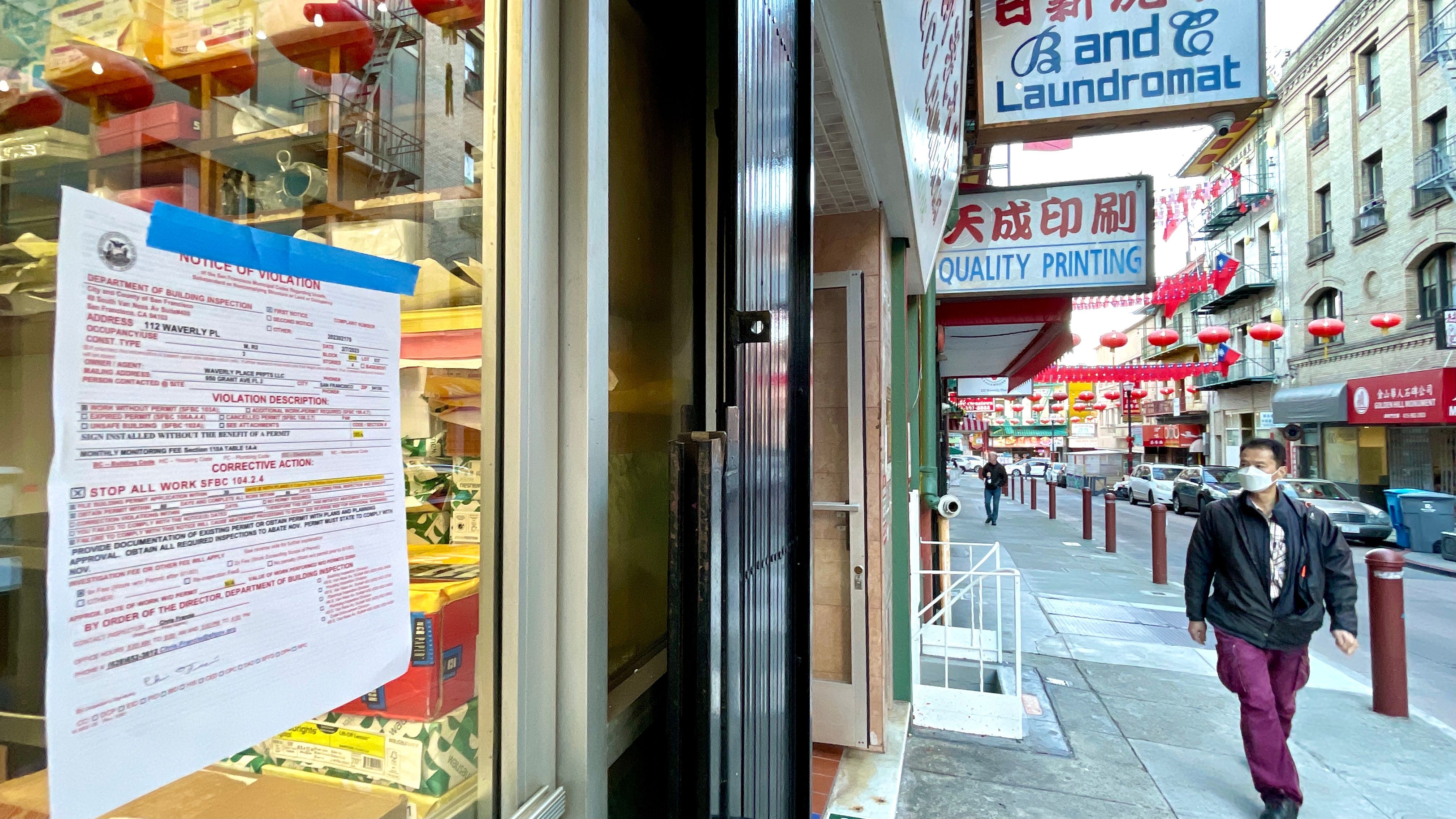 The City’s Department of Building Inspection posts a notice of violation at the glass door of Culture-Lite Printing Co. on February 8. Photo by Portia Li