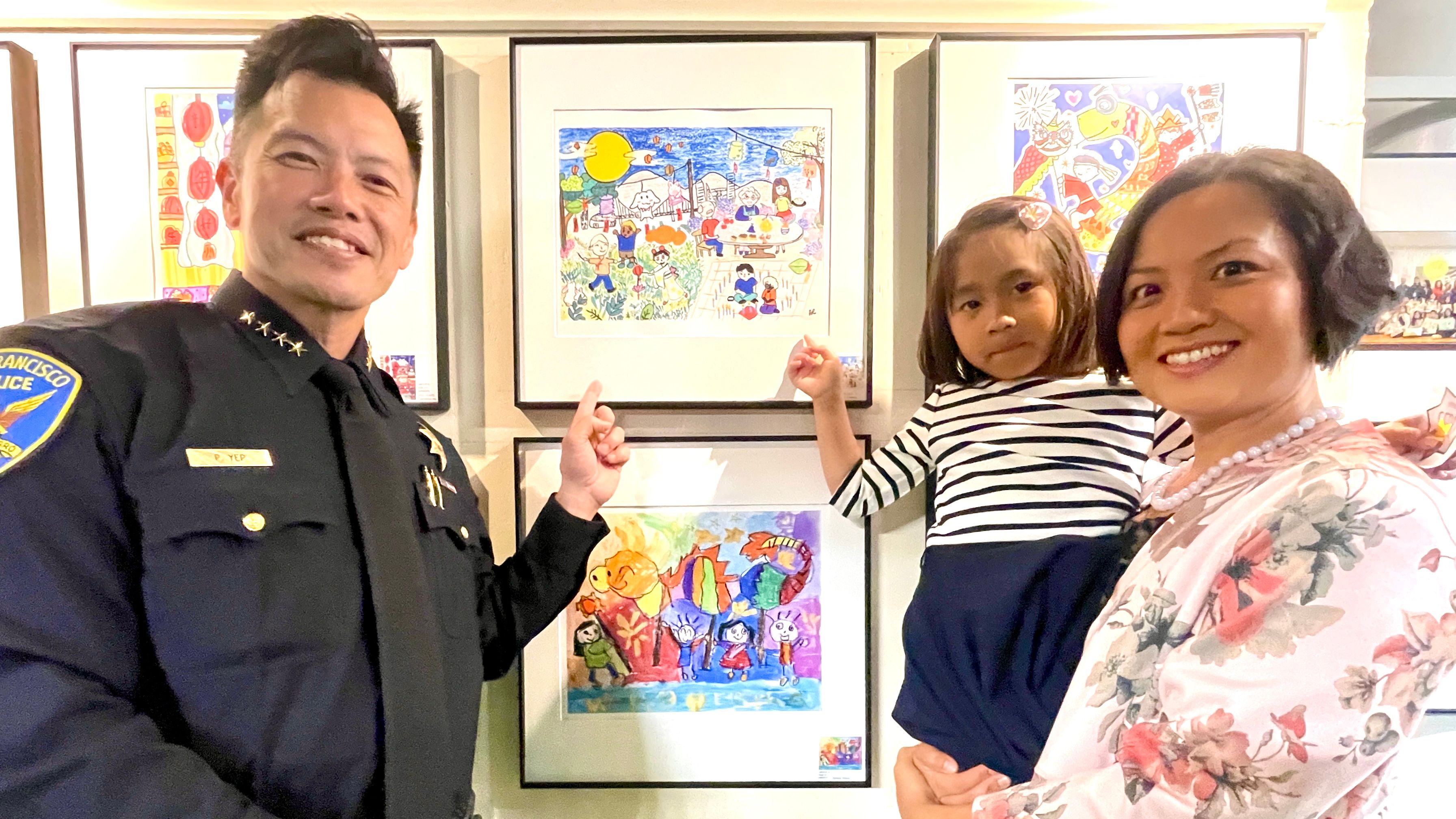 Agnes Cheung (center) is the 1st place winner of the Ages 4-7 group art contest. The theme of her winning artwork was Mid-Autumn Festival where family members and friends gathered together to celebrate. Interim Police Chief Paul Yep (left) and APA Family Support Services Executive Director Fanny Lam (right) express admiration to the talented young artist. Photo by Portia Li
