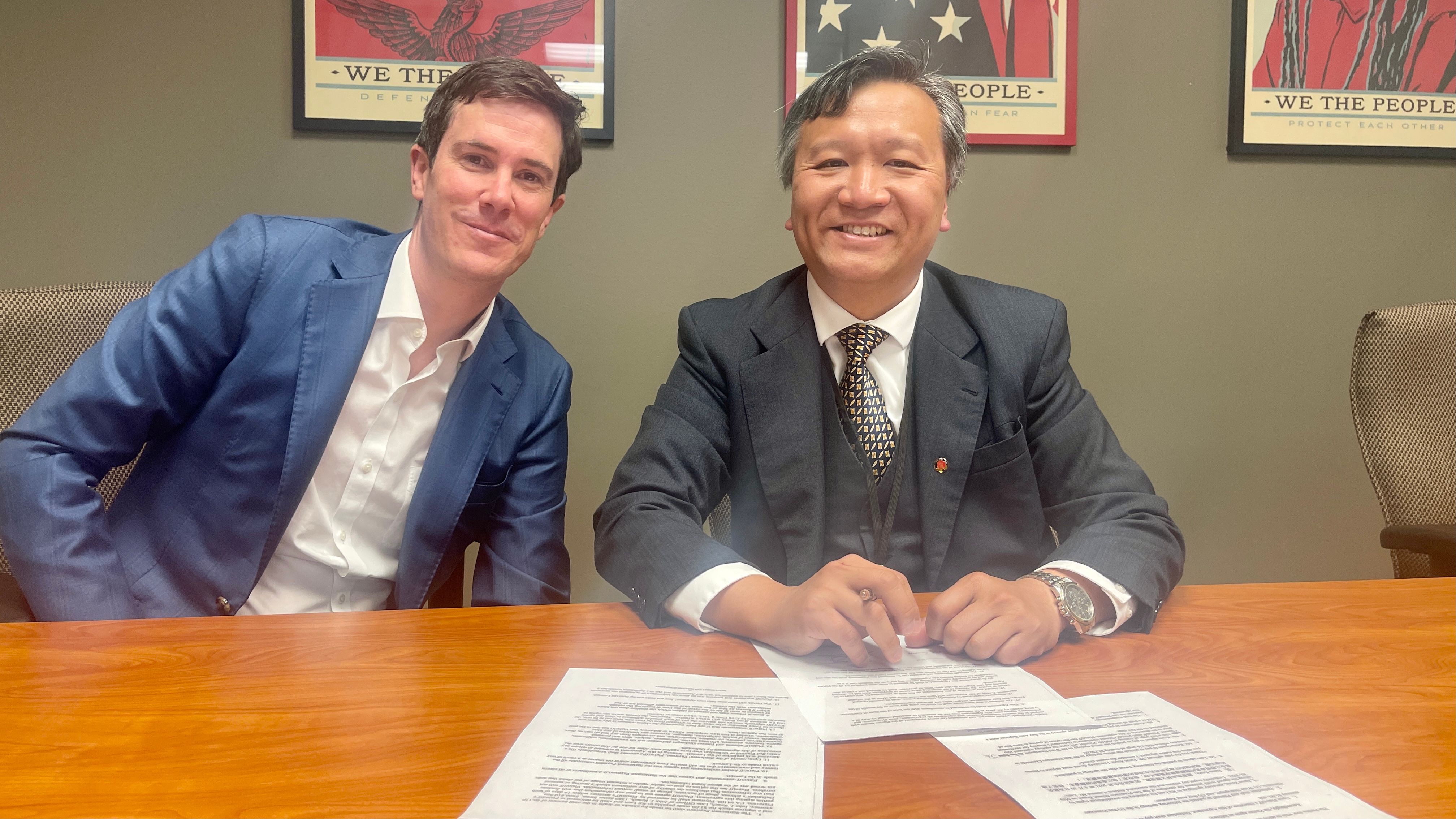 Kit Lam (right) signs the settlement of the civil lawsuit filed against Jason Kruta in front of his attorney John Roach (left) for $1 compensation. Photo by Portia Li