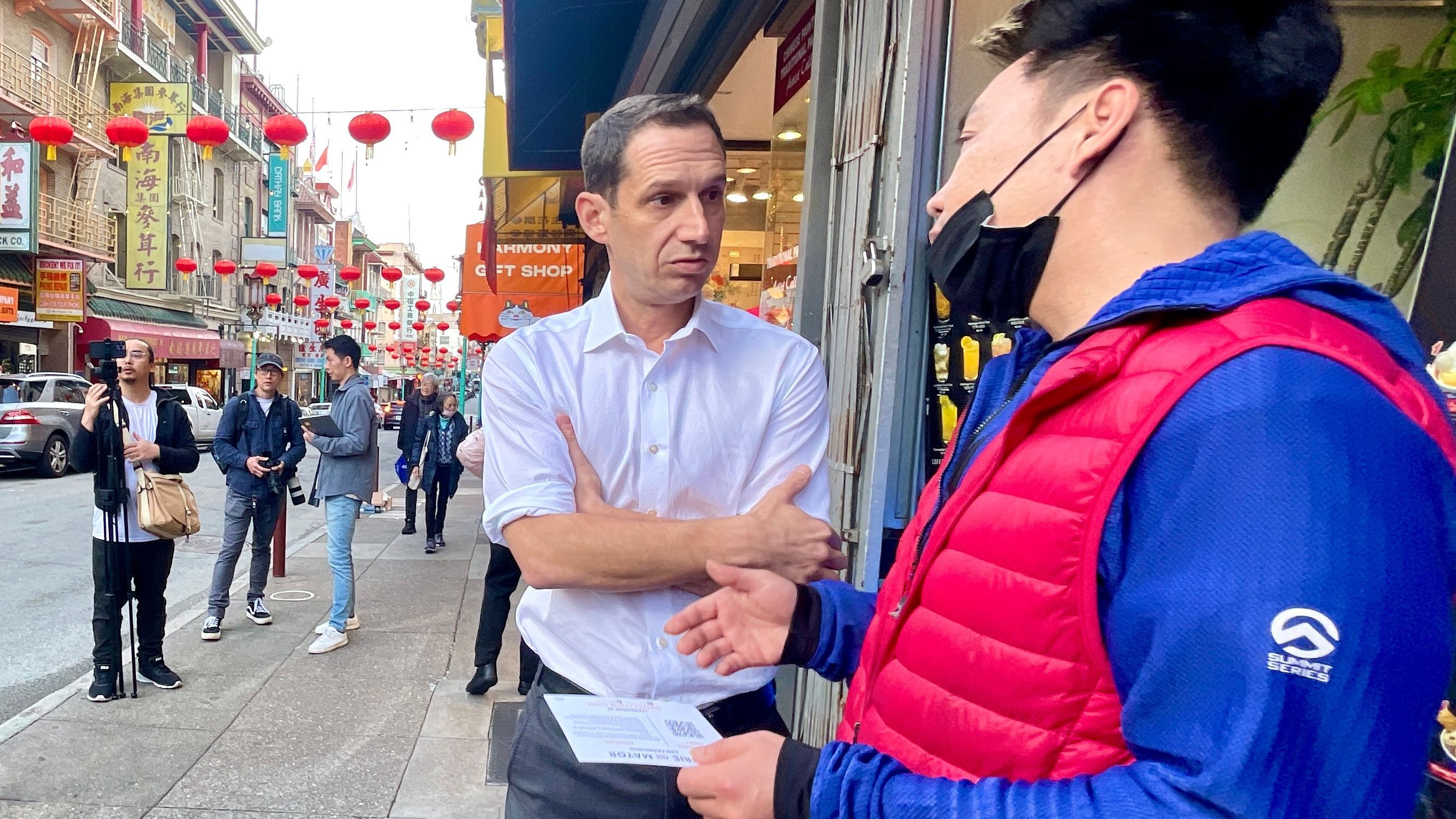 Mayoral candidate Daniel Lurie listens to Simon Chan, owner of Magical Ice Cream on Grant Avenue. Photo by Portia Li