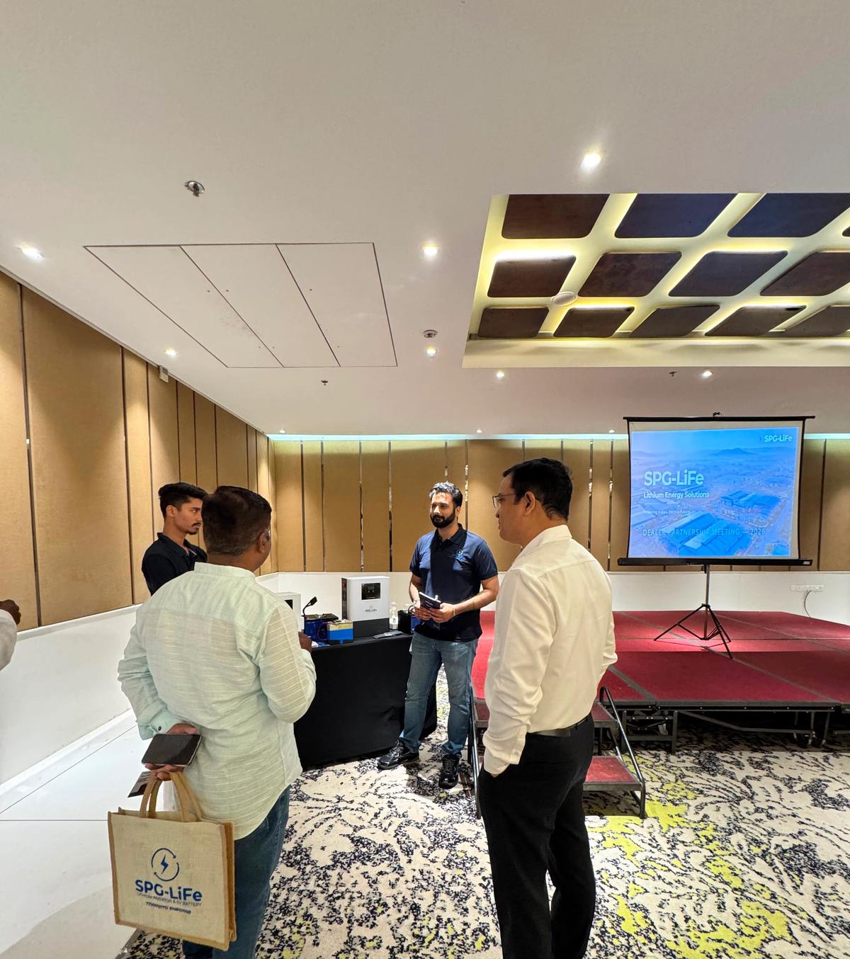 SPG LiFe application engineer discussing a battery requirement with a customer, alongside a four-step design arc, an exploded battery pack diagram and finished battery packs