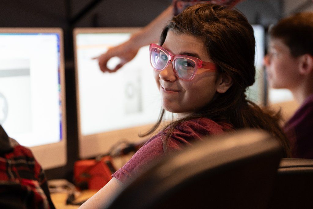 Student at computer smiling