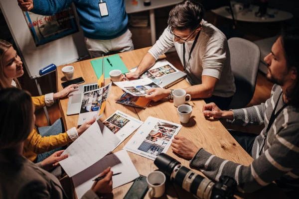 editores escolhendo fotos sobre uma mesa