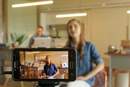 mulher com celular no tripe