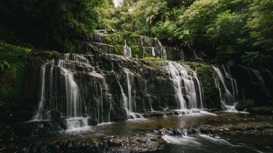 Waterfalls down rocks with trees