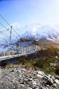A swing bridge on the Hooker Valley Track beneath the snow-capped Southern Alps