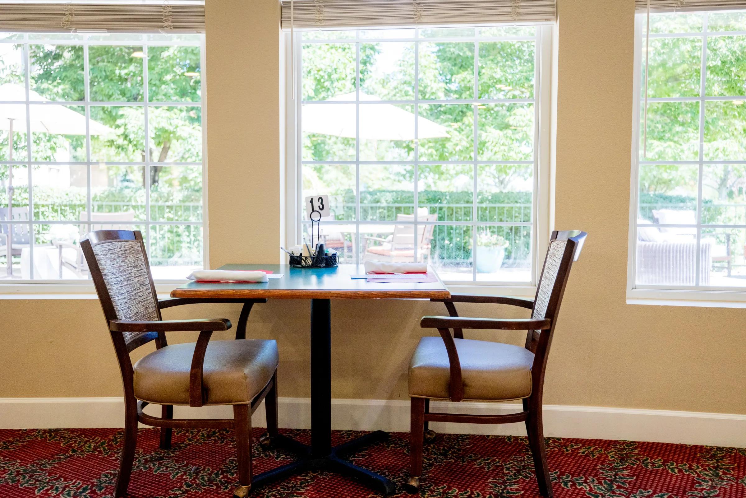 Gardens at Columbine dining table for two at a window overlooking the patio