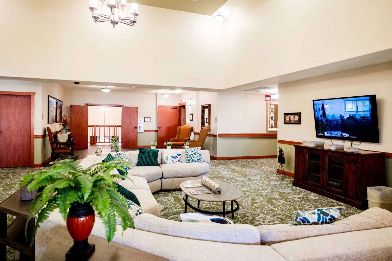 Gardens on Quail family room with TV armoire, green fern, and sectional sofa