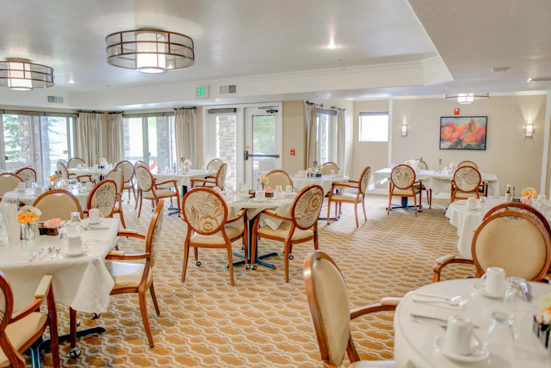 Golden Pond main dining room with round tables, upholstered chairs, and arched walls