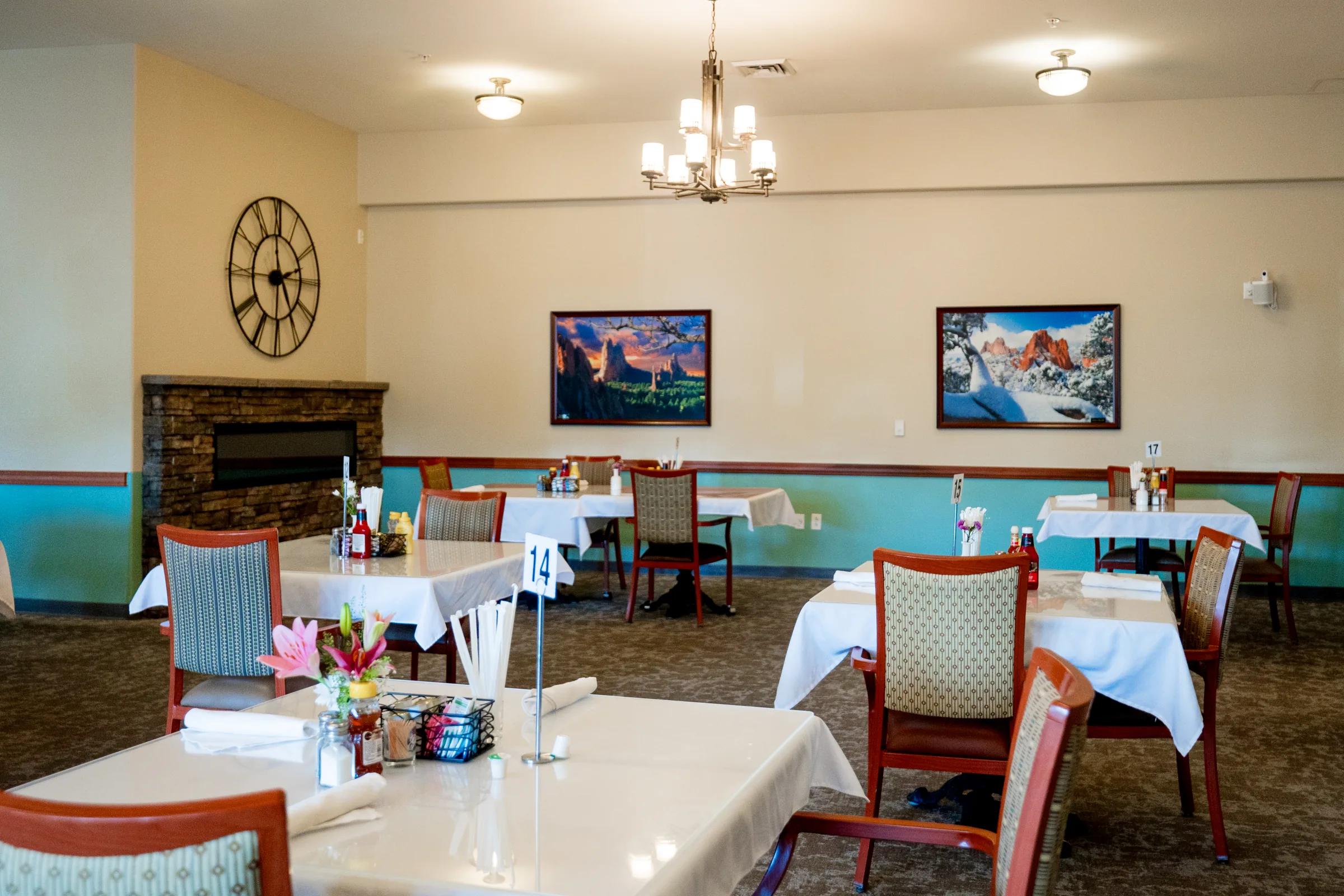 Gardens on Quail dining area with chandelier, clock, canvas art, and set tables