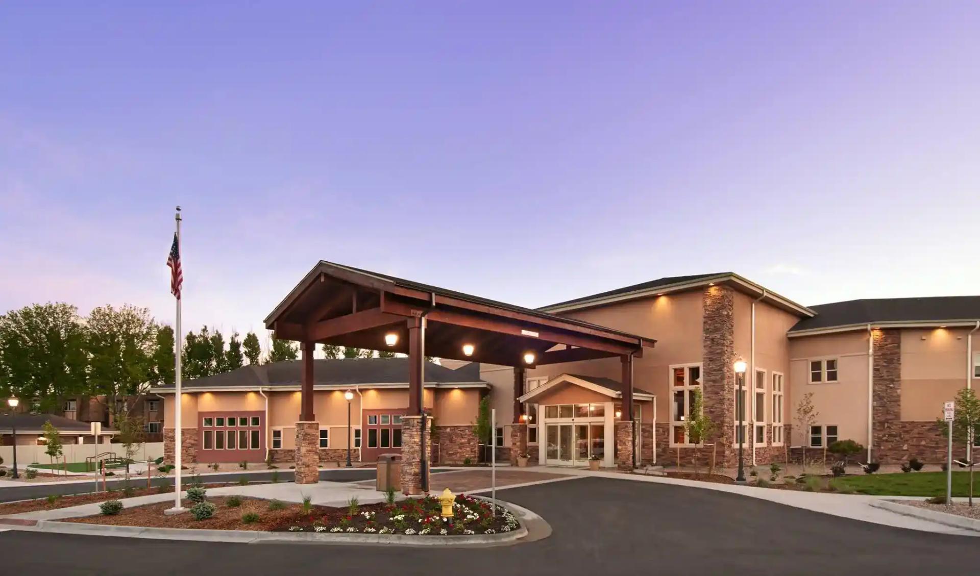 Gardens on Quail main entrance and landscaped drive at dusk