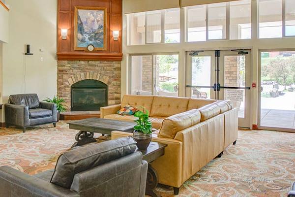 Golden Pond lounge with fireplace, sofa seating, and courtyard windows