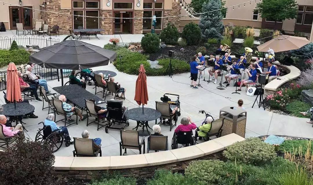 Courtyard performance with residents seated around patio tables