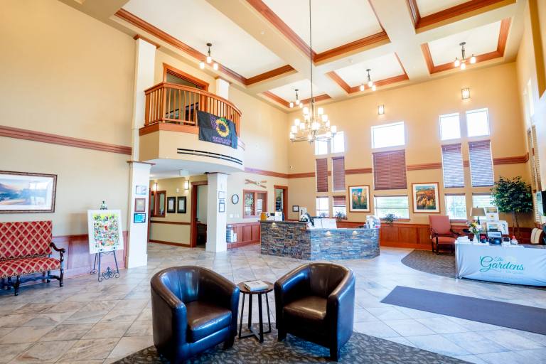 Gardens on Quail residents reading and chatting in the vaulted nautical lounge with stone fireplace