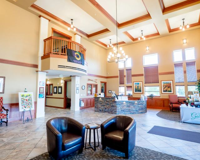 Gardens on Quail residents reading and chatting in the vaulted nautical lounge with stone fireplace