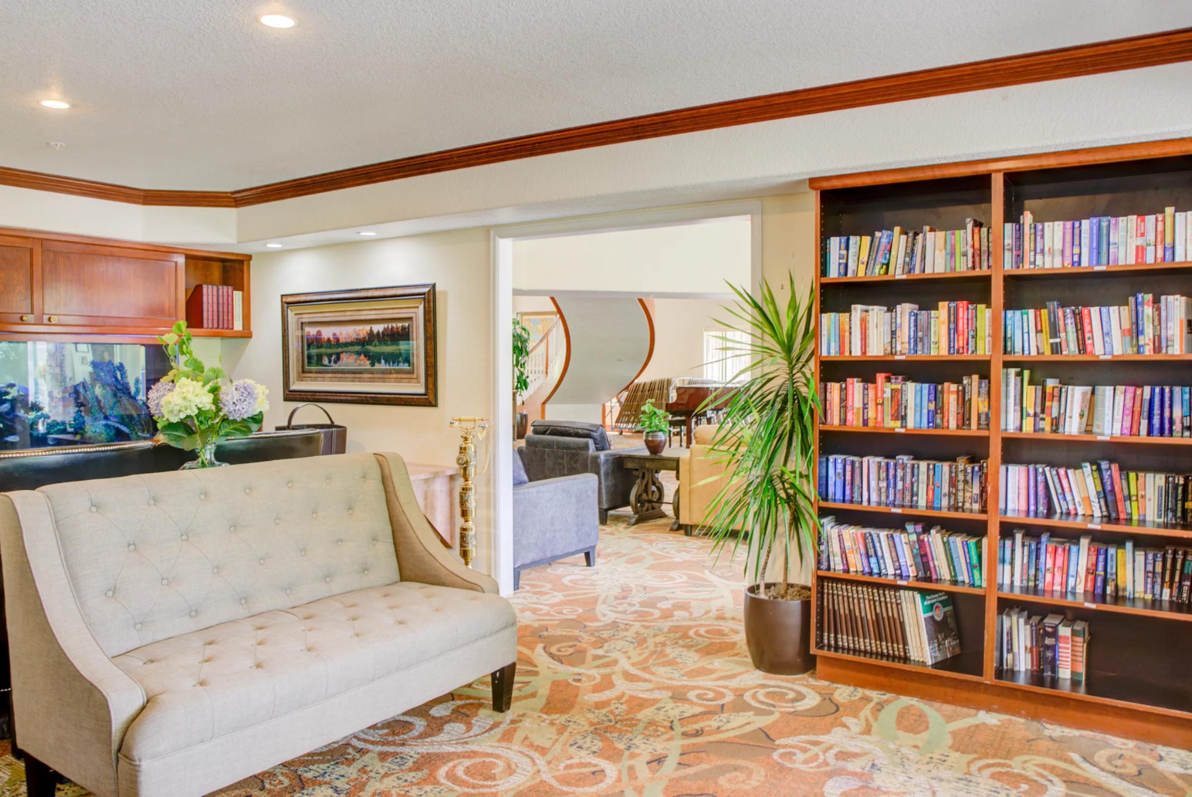 Golden Pond second-floor family room with a sofa, aquarium, built-in bookshelves, and views into the adjoining lounge.
