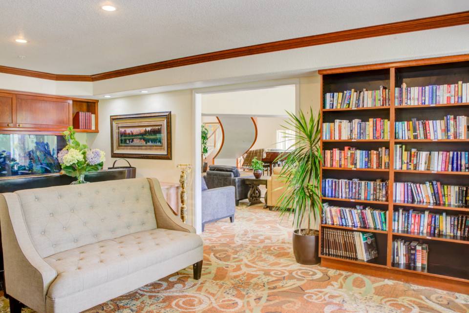 Golden Pond second-floor family room with a sofa, aquarium, built-in bookshelves, and views into the adjoining lounge.