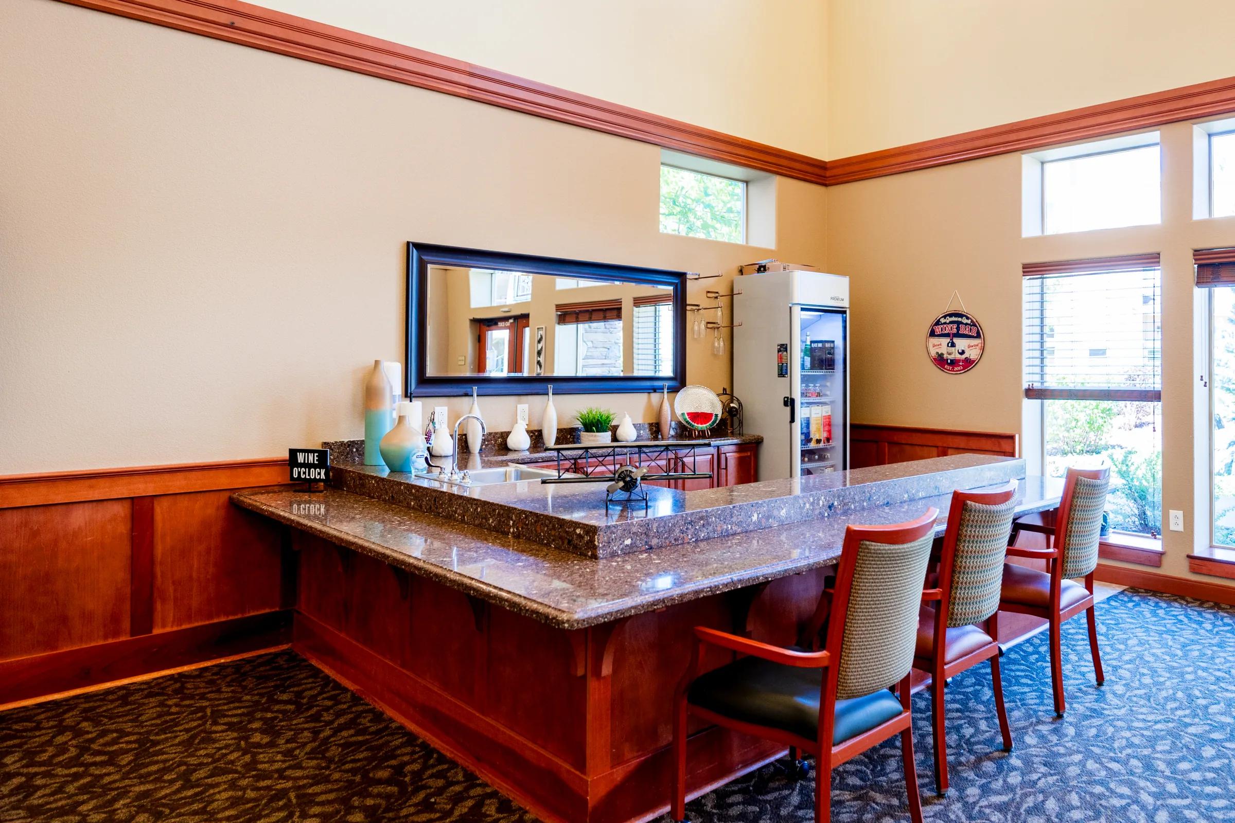 Gardens on Quail wine bar with granite counter, mirror, and 'Wine O'Clock' sign