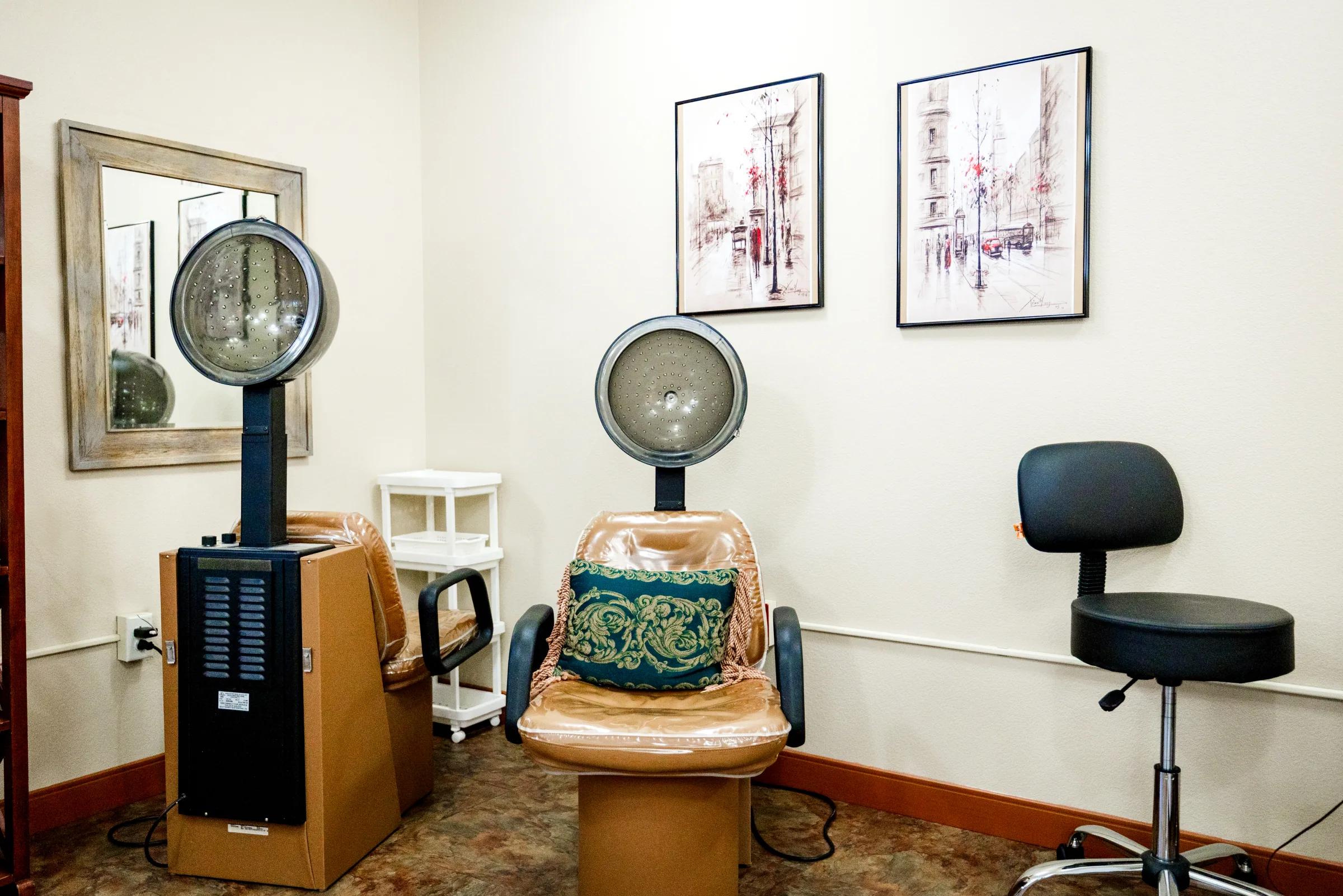 Gardens on Quail on-site salon with hooded dryer chairs, a wash station, and Paris art prints.
