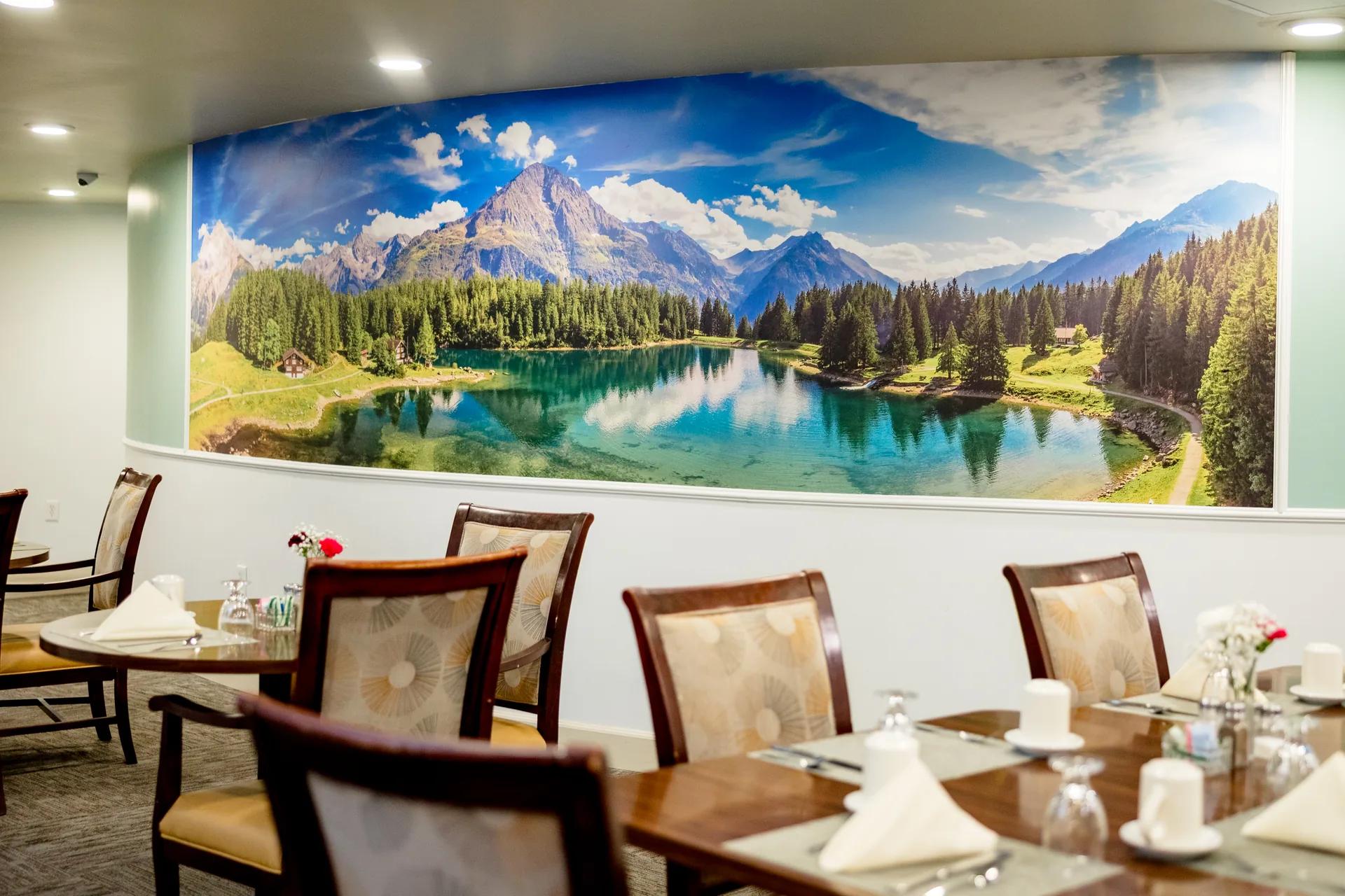 Stonebridge dining room with set tables and a mountain lake mural