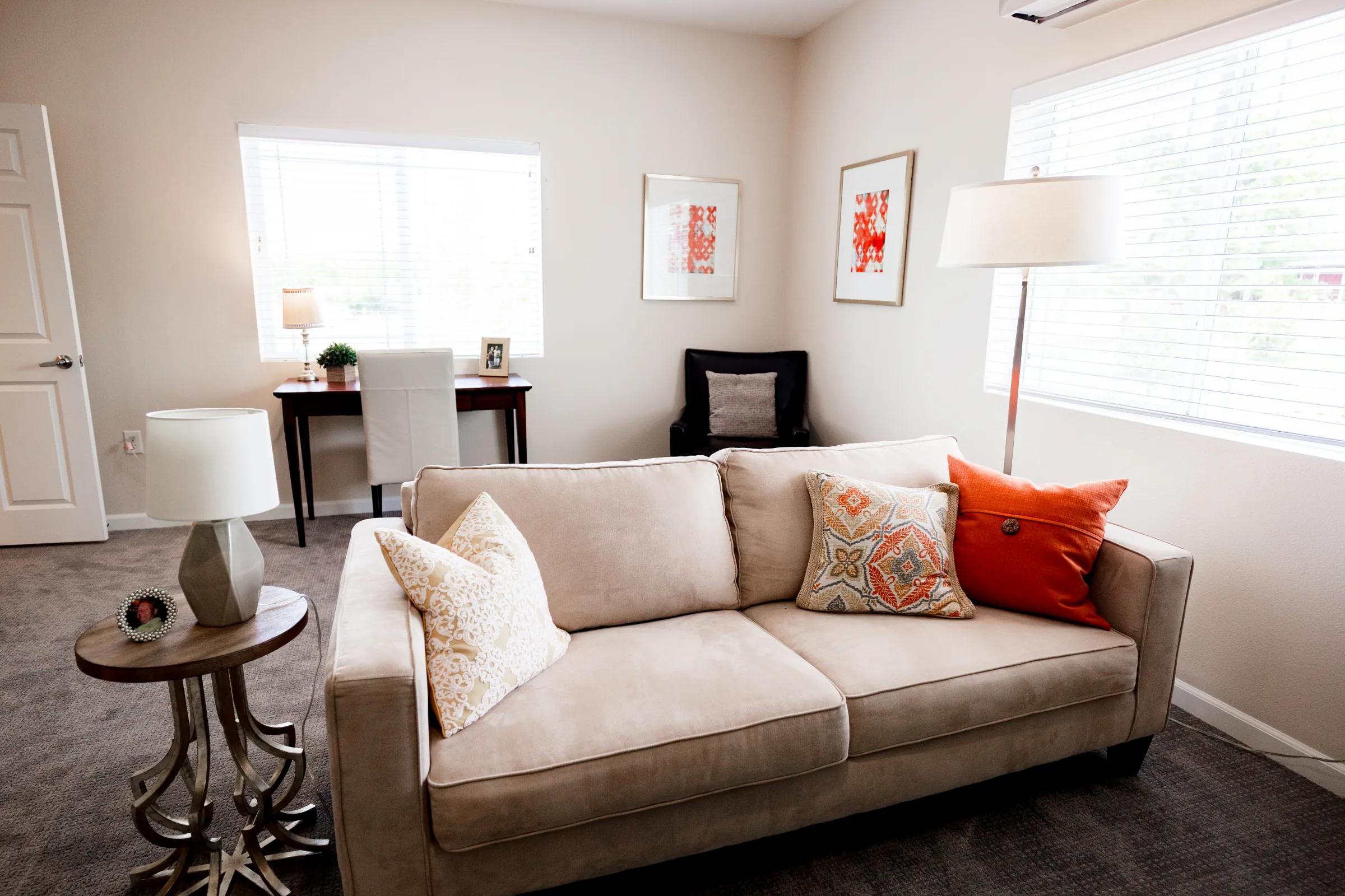 Stonebridge apartment living room with a tan sofa, desk, and natural light