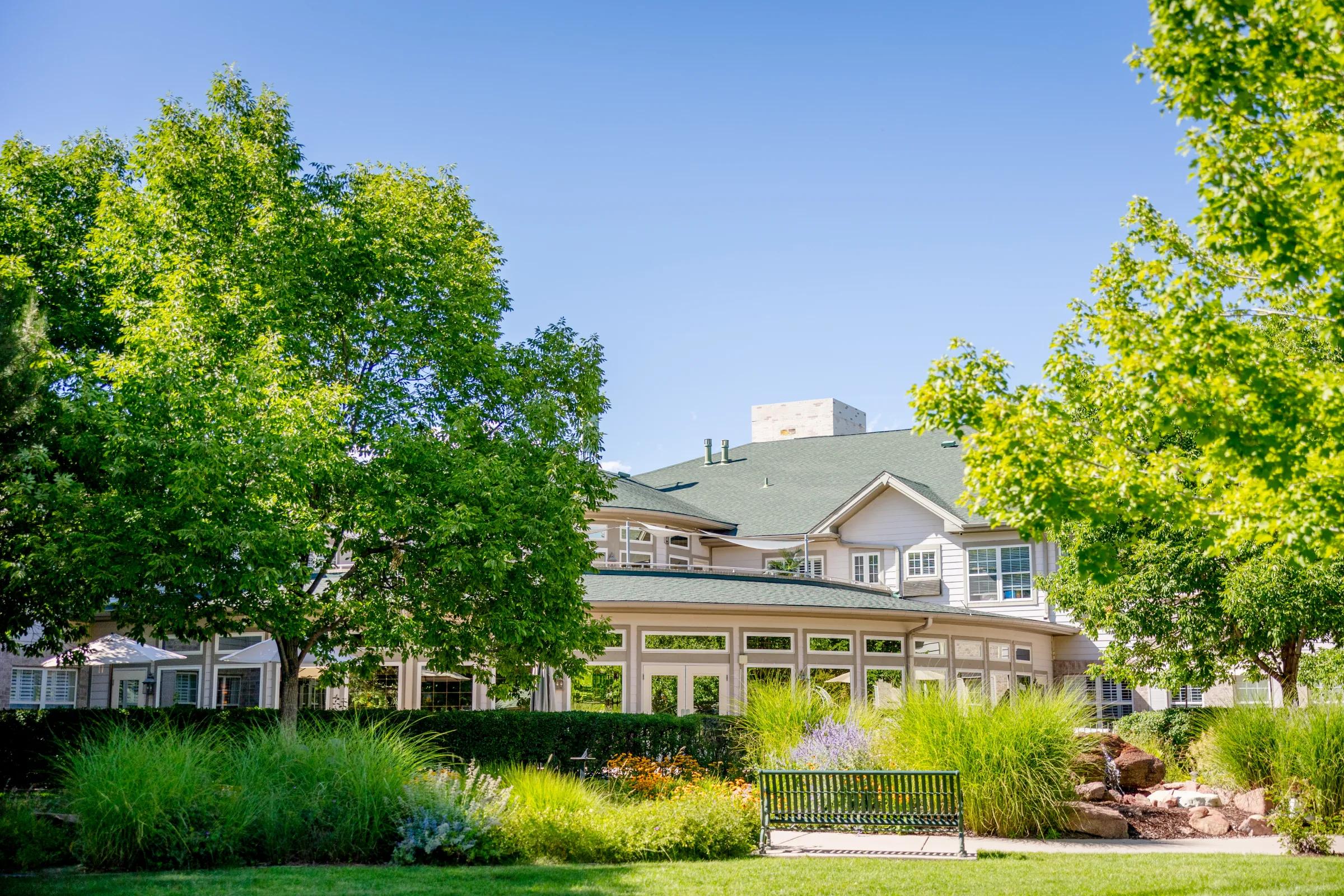 Gardens at Columbine back exterior with conservatory windows and landscaped garden