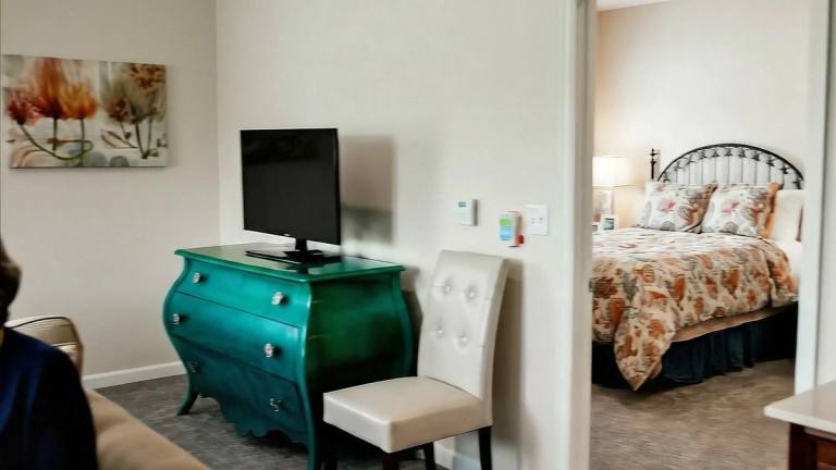 Gardens at Columbine residents visiting in a bright apartment living room
