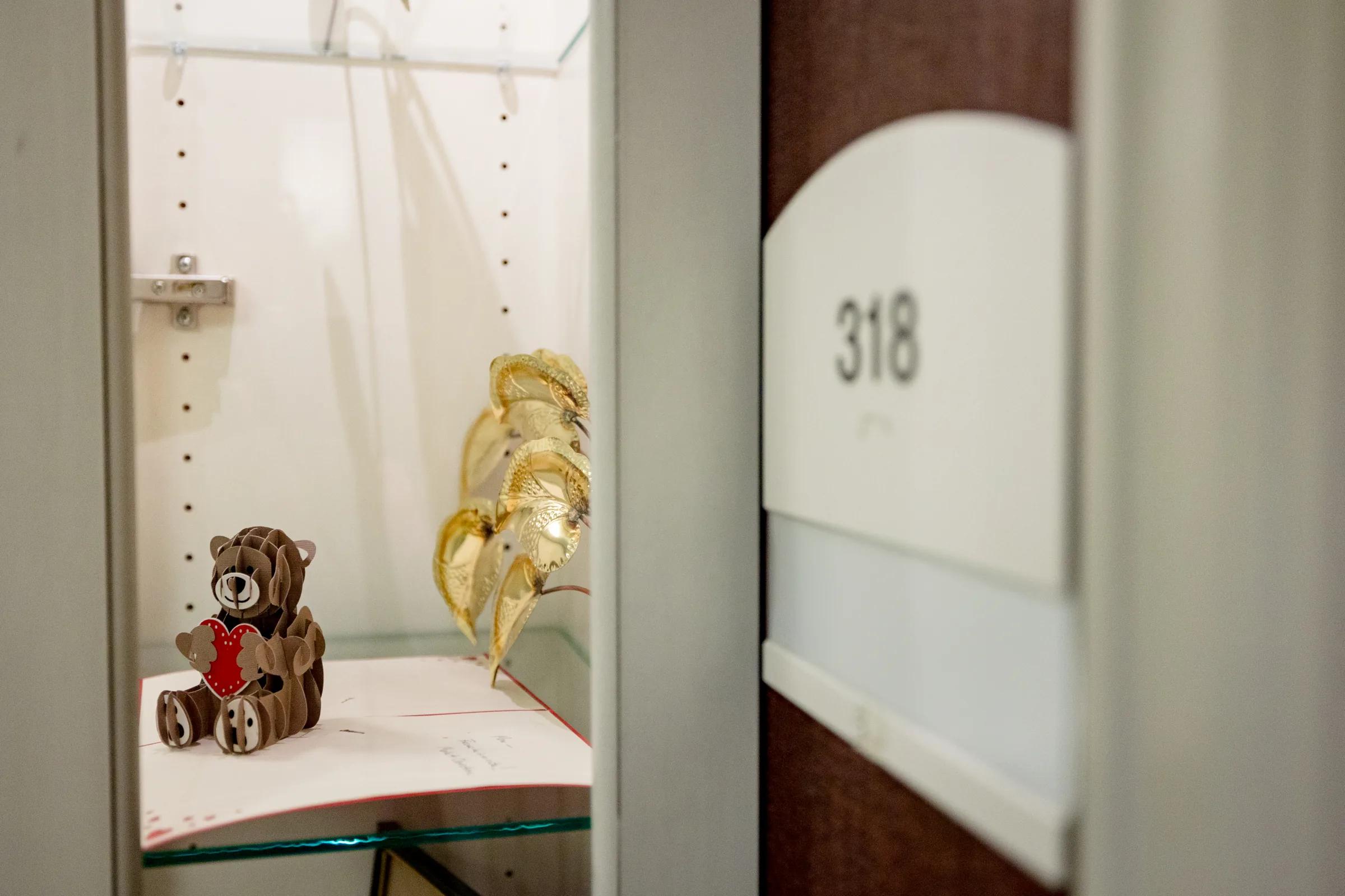 Gardens at Columbine apartment entry with a teddy bear display beside the door