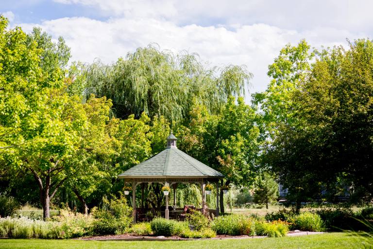 Gardens at Columbine gazebo nestled among willows and summer foliage