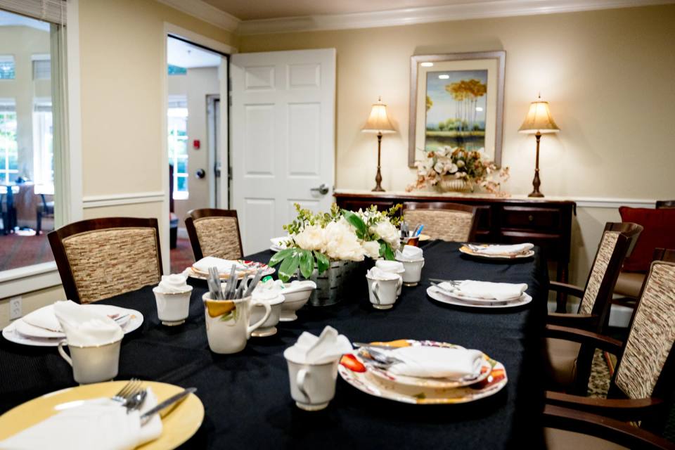 Gardens at Columbine private dining table set with black linen, white china, and floral centerpiece