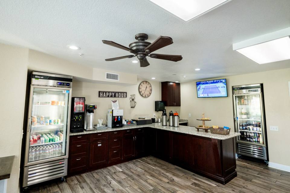 Golden Pond Happy Hour bar with beverage coolers, coffee station, and TV