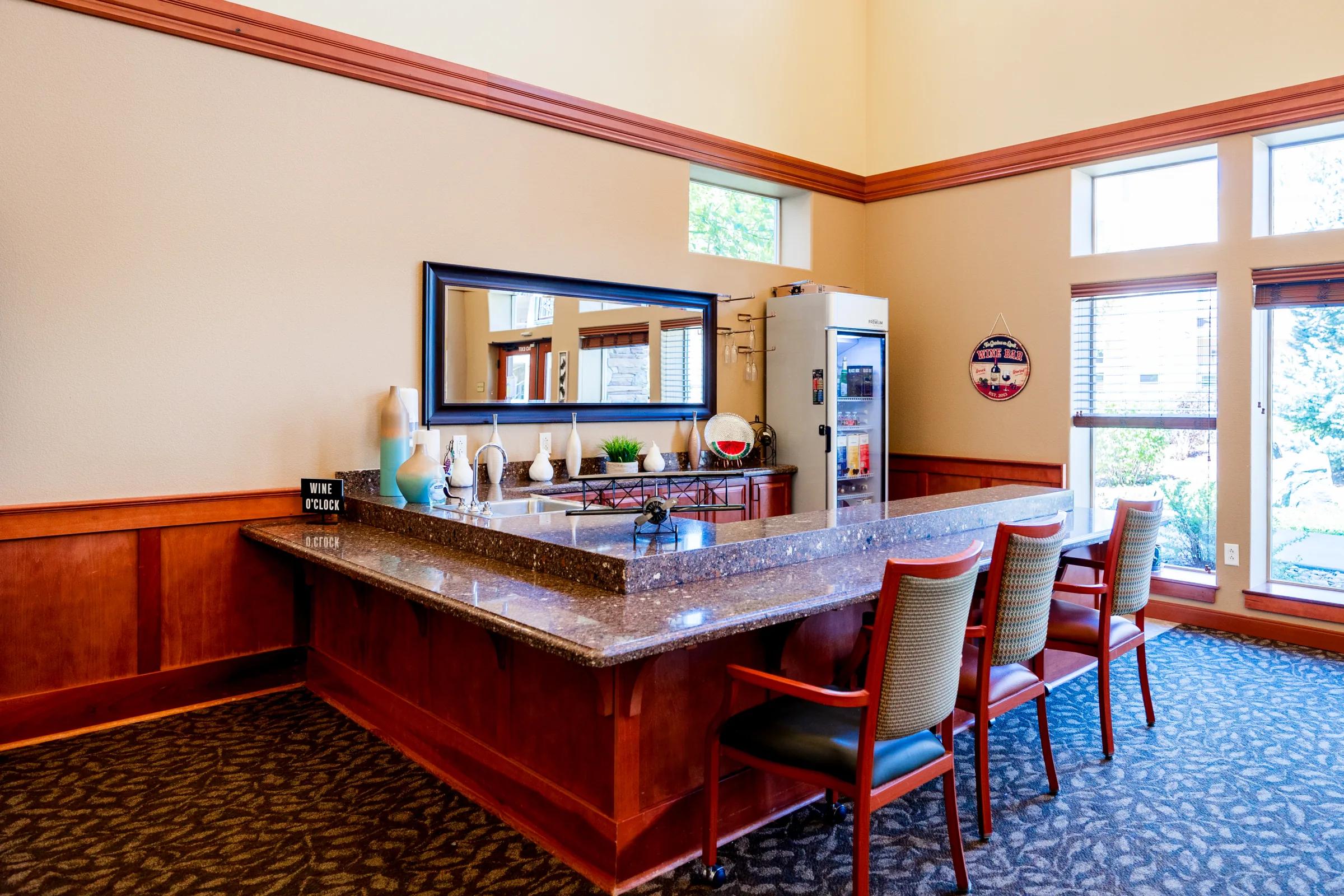 Gardens on Quail wine bar with bar stools, granite counter, and window seating