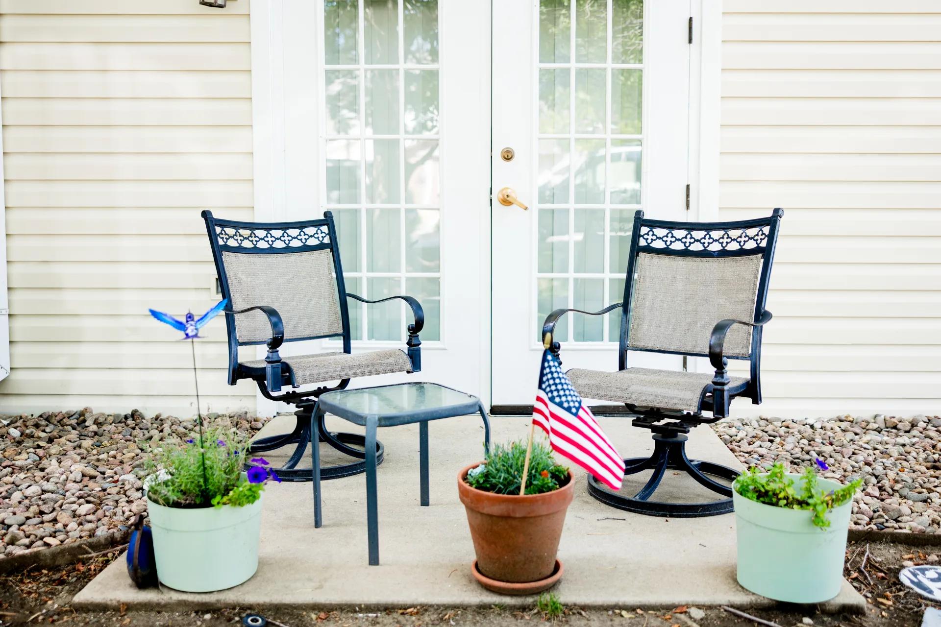Two chairs and a small table on a patio outside a Bear Creek apartment
