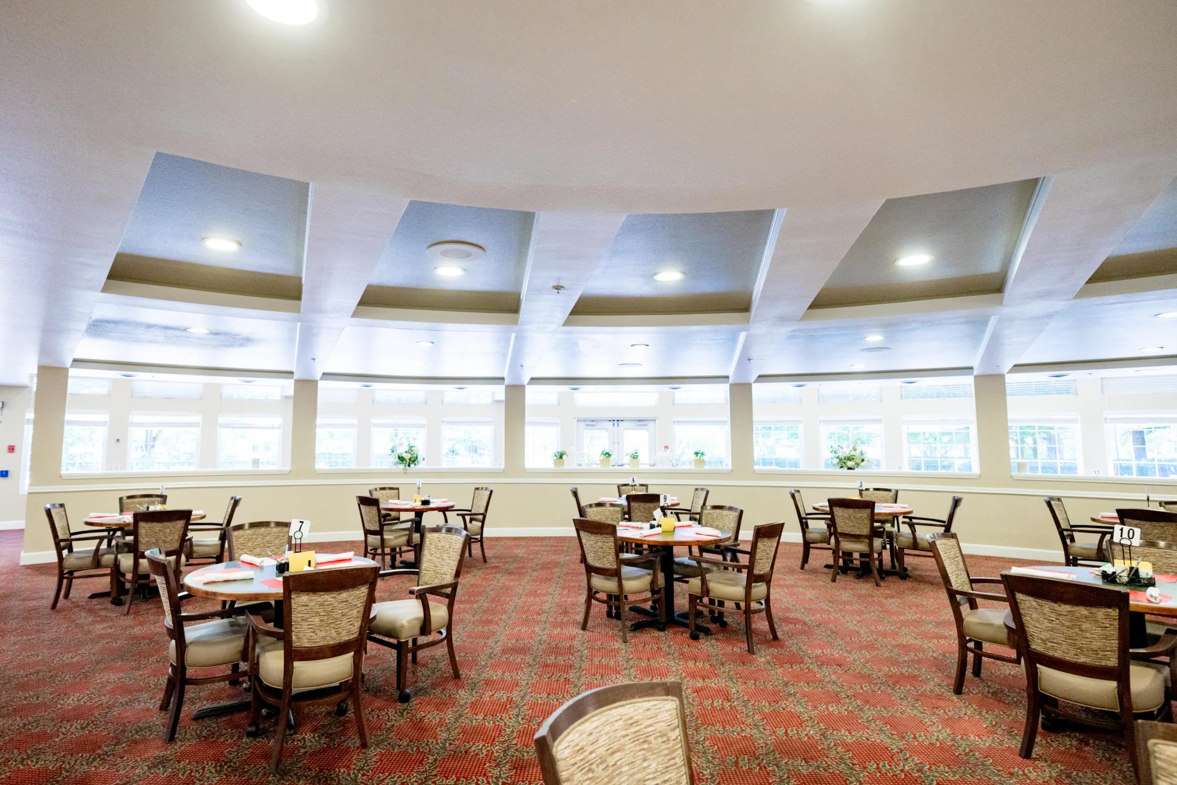 Gardens at Columbine main dining room with curved ceiling and many set tables