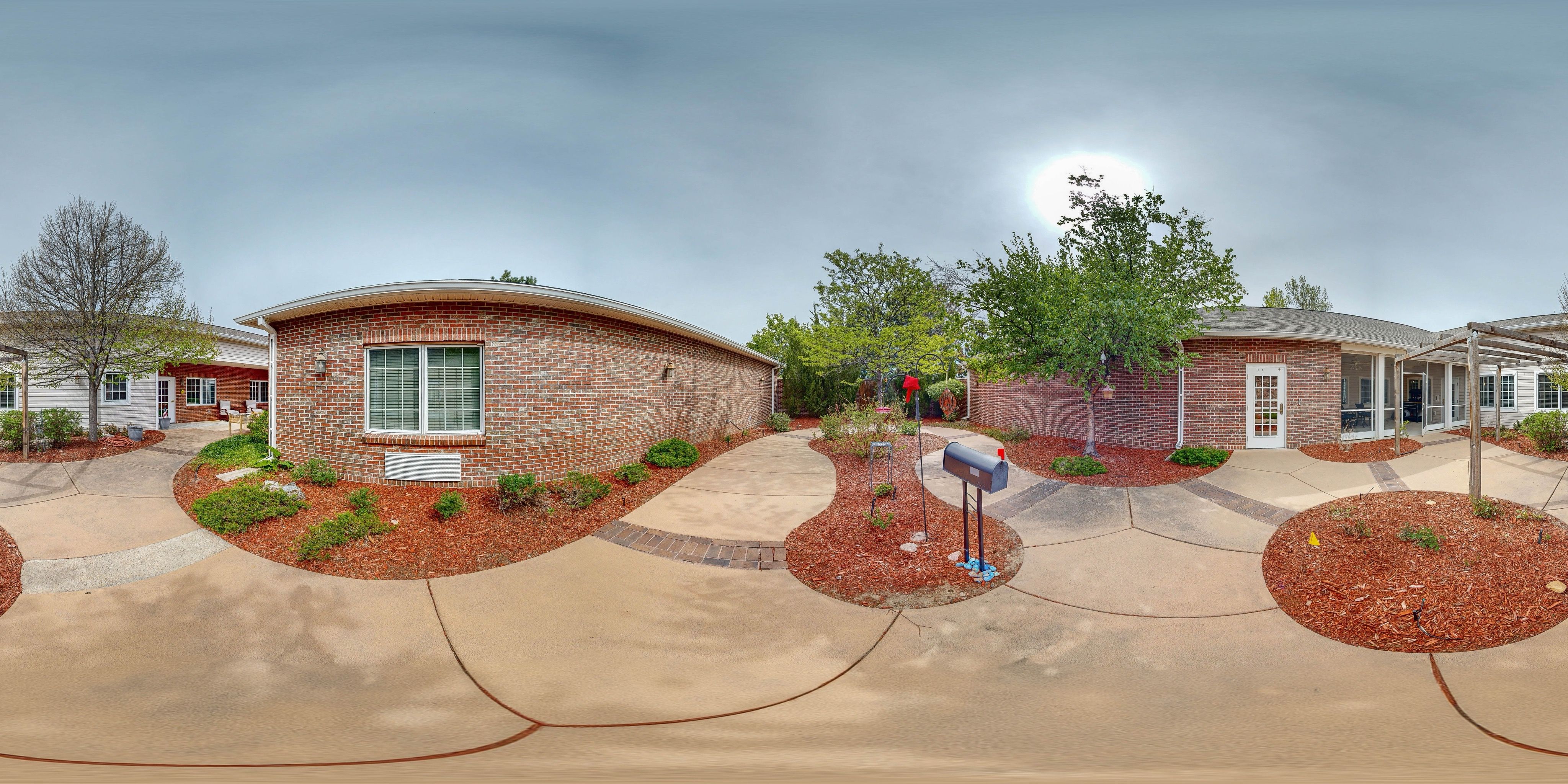360 panorama of Bear Creek's brick courtyard with walkway, garden beds, and mailbox