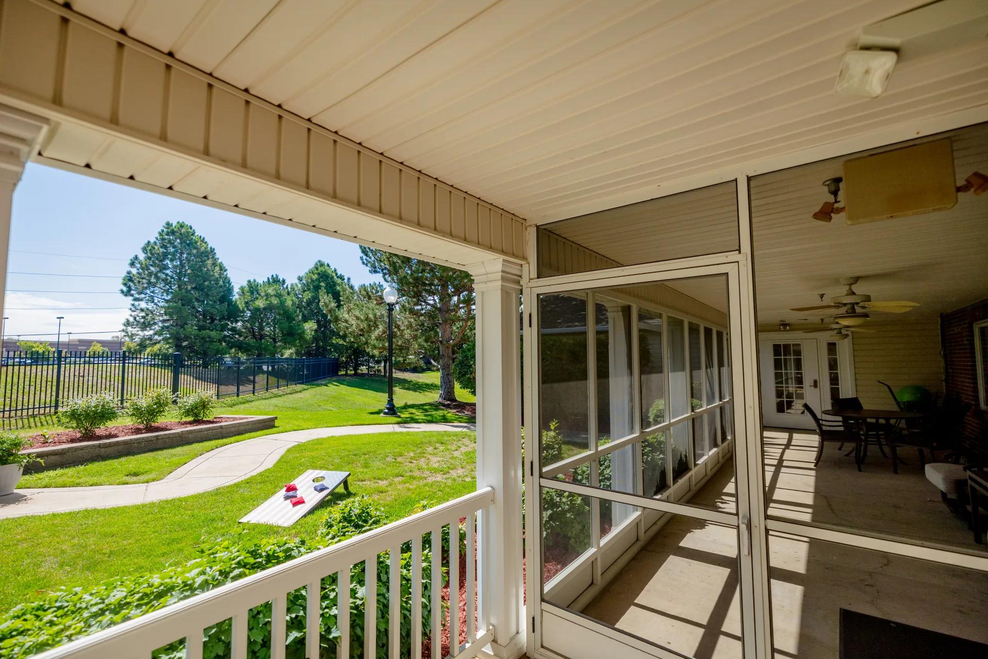 Covered patio overlooking a lawn with a cornhole board at Bear Creek
